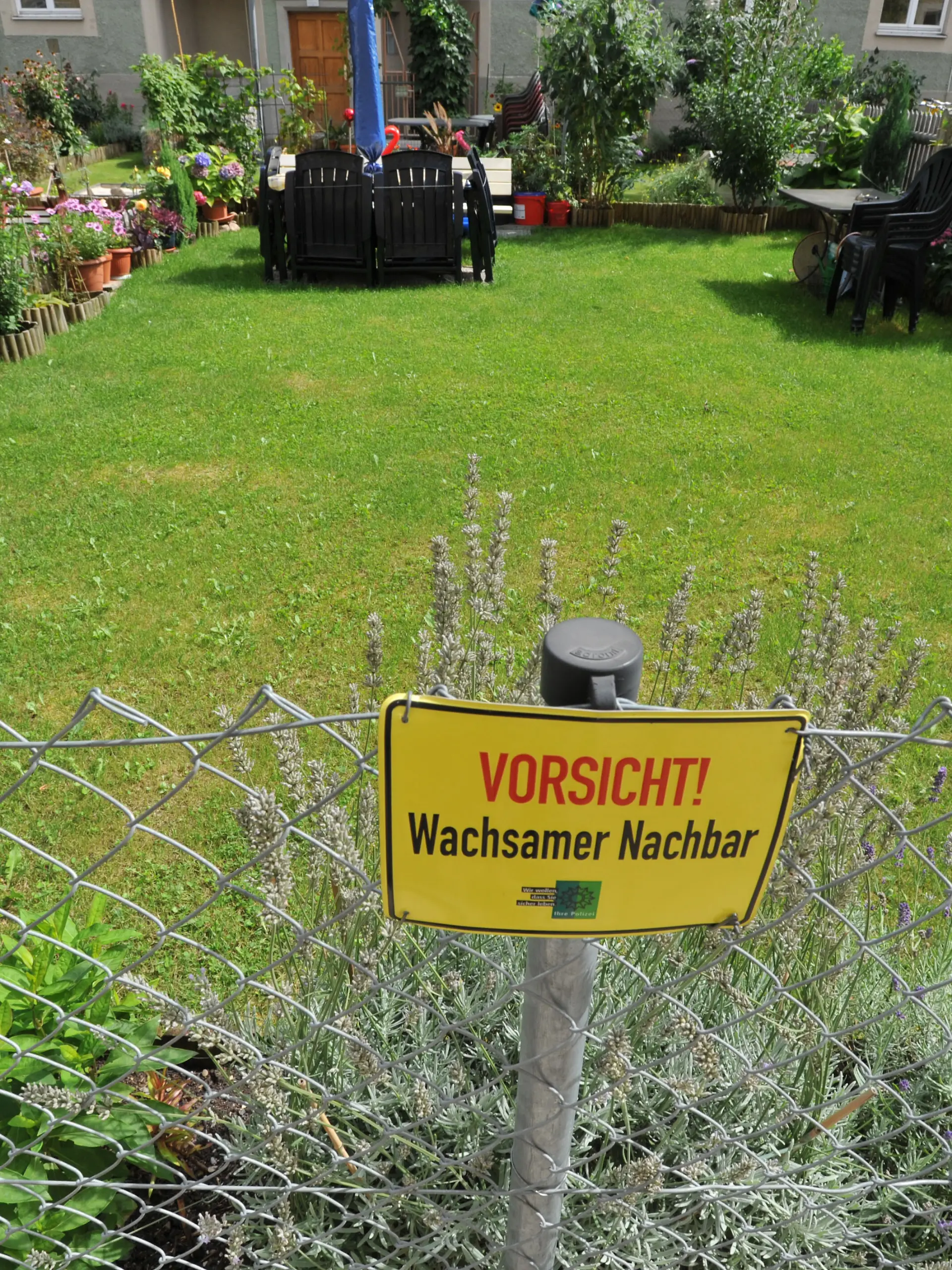 Schild "Vorsicht - Wachsamer Nachbar!" am Gartenzaun eines Wohnhauses in der "Alten Heide" im Münchner Norden., 07.09.2011