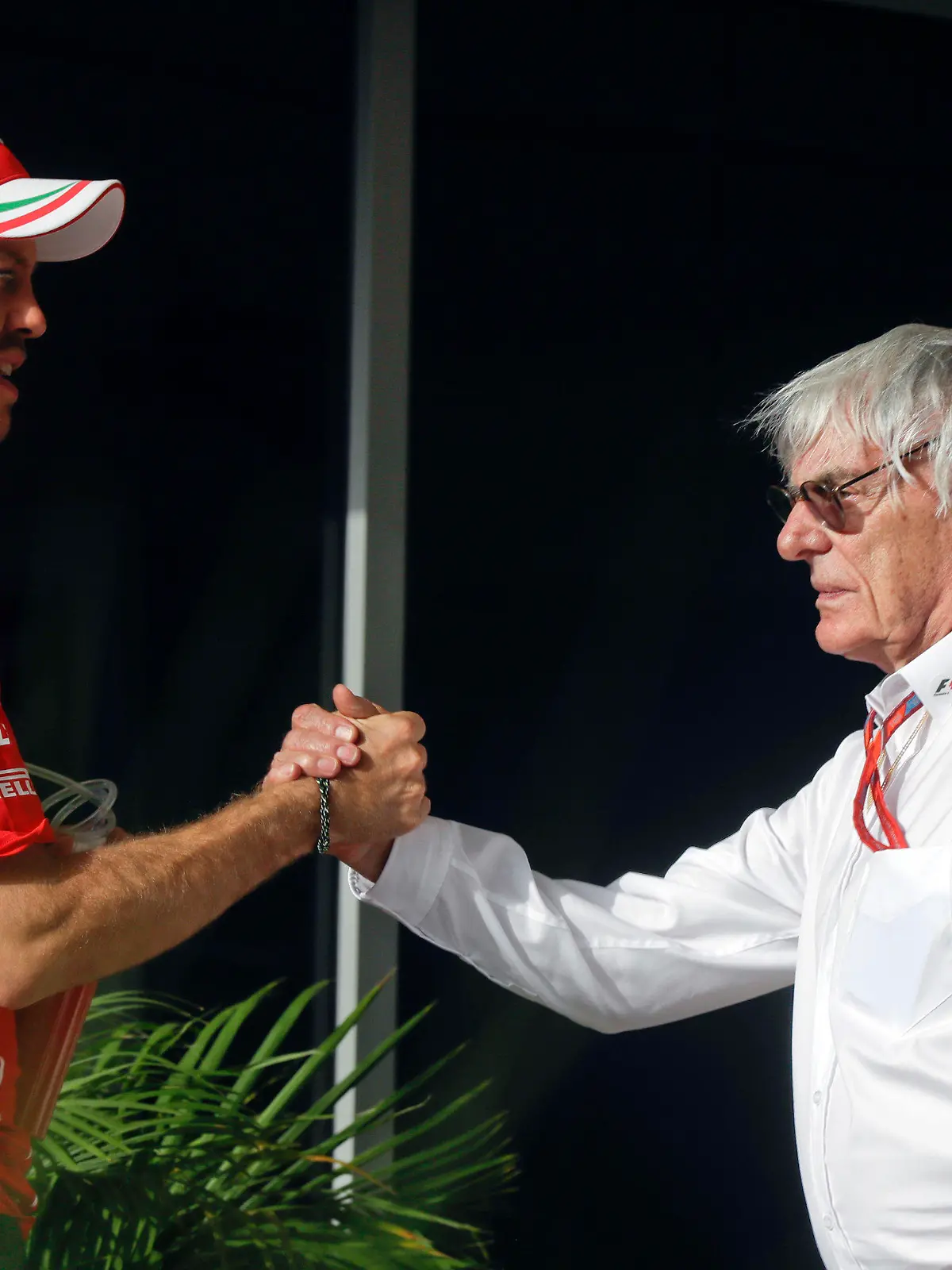 ARCHIV - 16.04.2017, Bahrain, Sakhir: Motorsport: Formel-1-Weltmeisterschaft, Grand Prix von Bahrain in as-Sachir (Bahrain). Der ehemalige Geschäftsführer der Formel-1, Bernie Ecclestone (r) begrüßt den deutschen Formel-1-Fahrer Sebastian Vettel vom Team Scuderia Ferrari im Fahrerlager. Foto: Luca Bruno/AP/dpa +++ dpa-Bildfunk +++