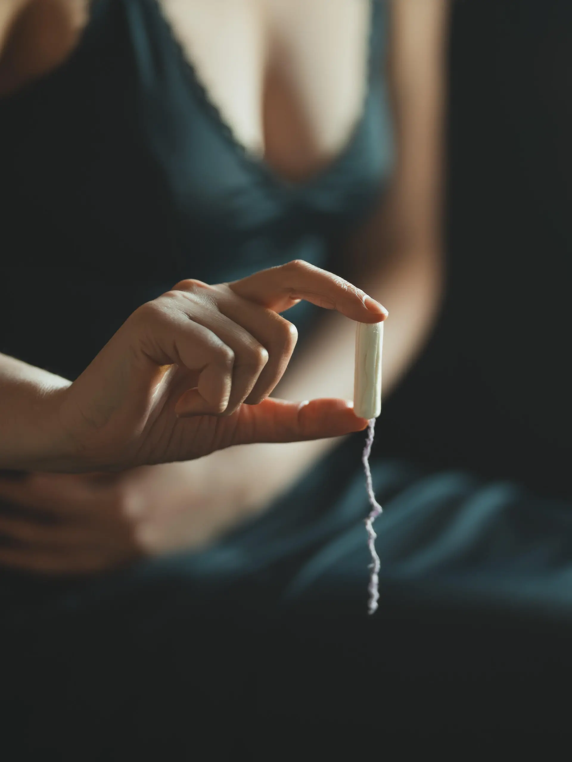Eine Frau hält ein Tampon in der Hand