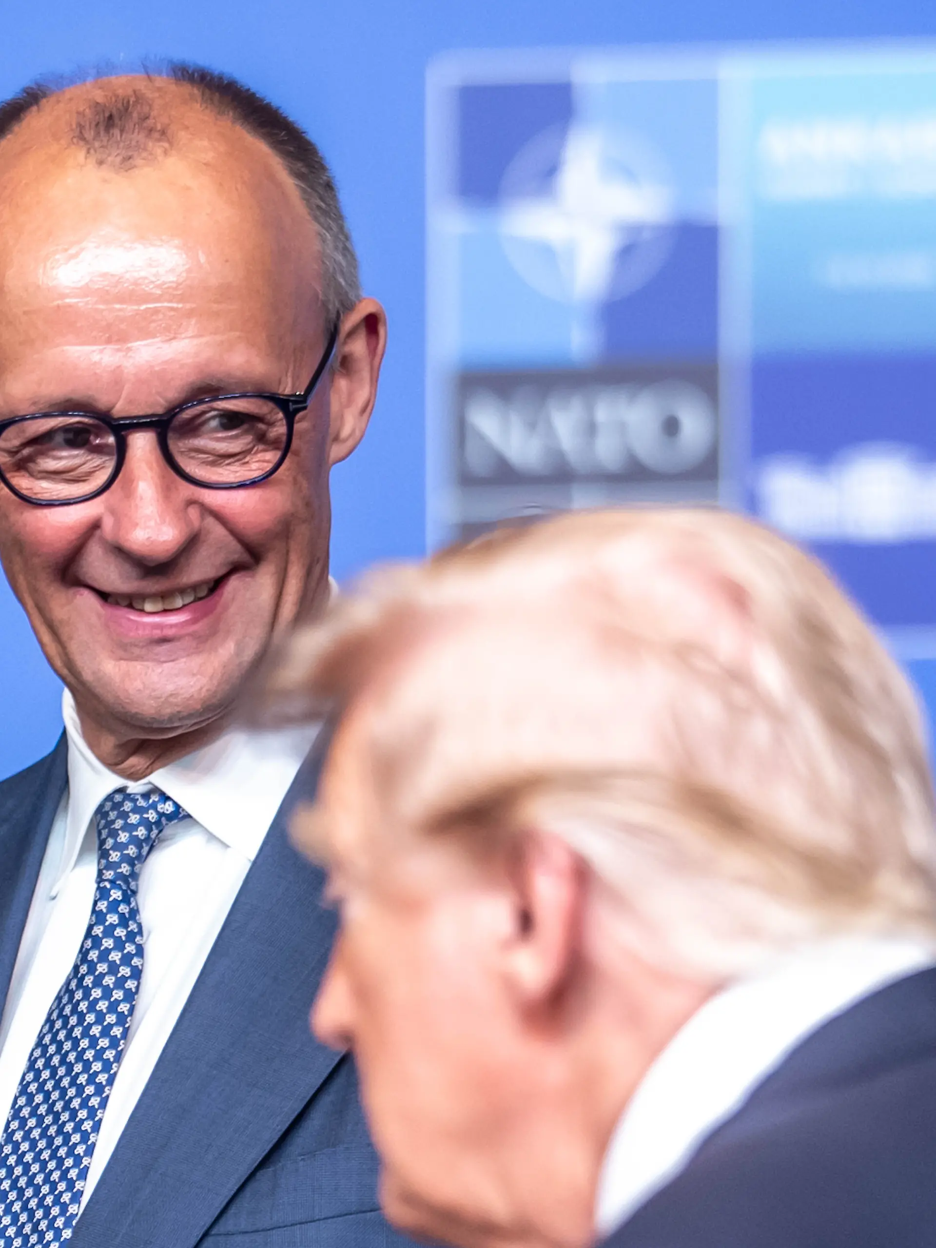 Bundeskanzler Friedrich Merz (CDU) steht beim Familienfoto hinter US-Präsident Donald Trump, beim Nato Gipfel dem Treffen des Nordatlantikrats auf Ebene der Staats- und Regierungschefs.