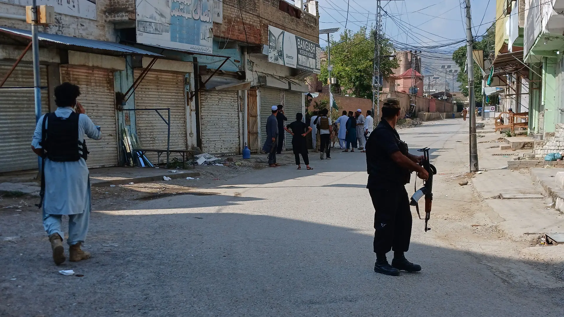 In this photo taken with a smartphone, police officers secure a road leading to the site of a powerful bomb at a mosque in Kohat, Pakistan, Friday, Sept. 18, 2026. (AP Photo/B.S. Gillani)
