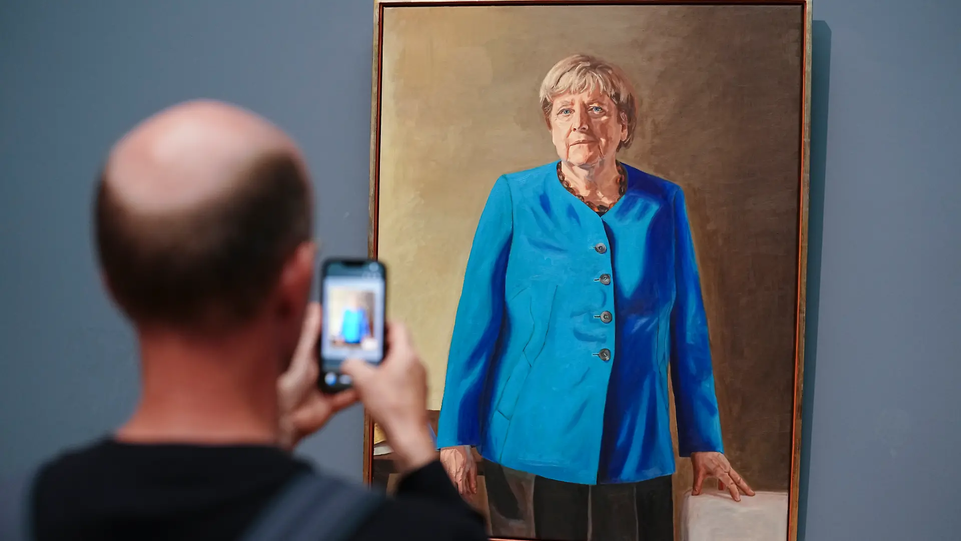Eine Besucherin macht mit dem Smartphone ein Foto vom Porträt der früheren Kanzlerin Merkel, das von Künstler Jérémie Queyras gezeichnet wurde für die Ahnengalerie im Bundeskanzleramt. Das Bild wird im Bode-Museum nun noch bis Anfang 2027 ausgestellt. (zu dpa: «Großer Andrang: Porträt von Merkel bleibt länger im Museum») +++ dpa-Bildfunk +++