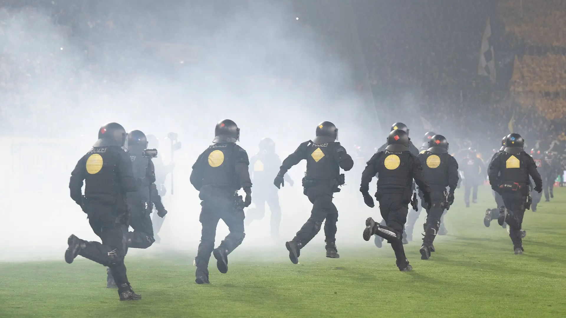04.04.2026, Sachsen, Dresden: Fußball, Männer, 2. Bundesliga, Dynamo Dresden - Hertha BSC, 28. Spieltag, im Rudolf-Harbig-Stadion, Polizisten laufen während einer Spielunterbrechung im Stadion auf das Spielfeld. Foto: Sebastian Kahnert/dpa - WICHTIGER HINWEIS: Gemäß den Vorgaben der DFL Deutsche Fußball Liga bzw. des DFB Deutscher Fußball-Bund ist es untersagt, in dem Stadion und/oder vom Spiel angefertigte Fotoaufnahmen in Form von Sequenzbildern und/oder videoähnlichen Fotostrecken zu verwerten bzw. verwerten zu lassen. +++ dpa-Bildfunk +++