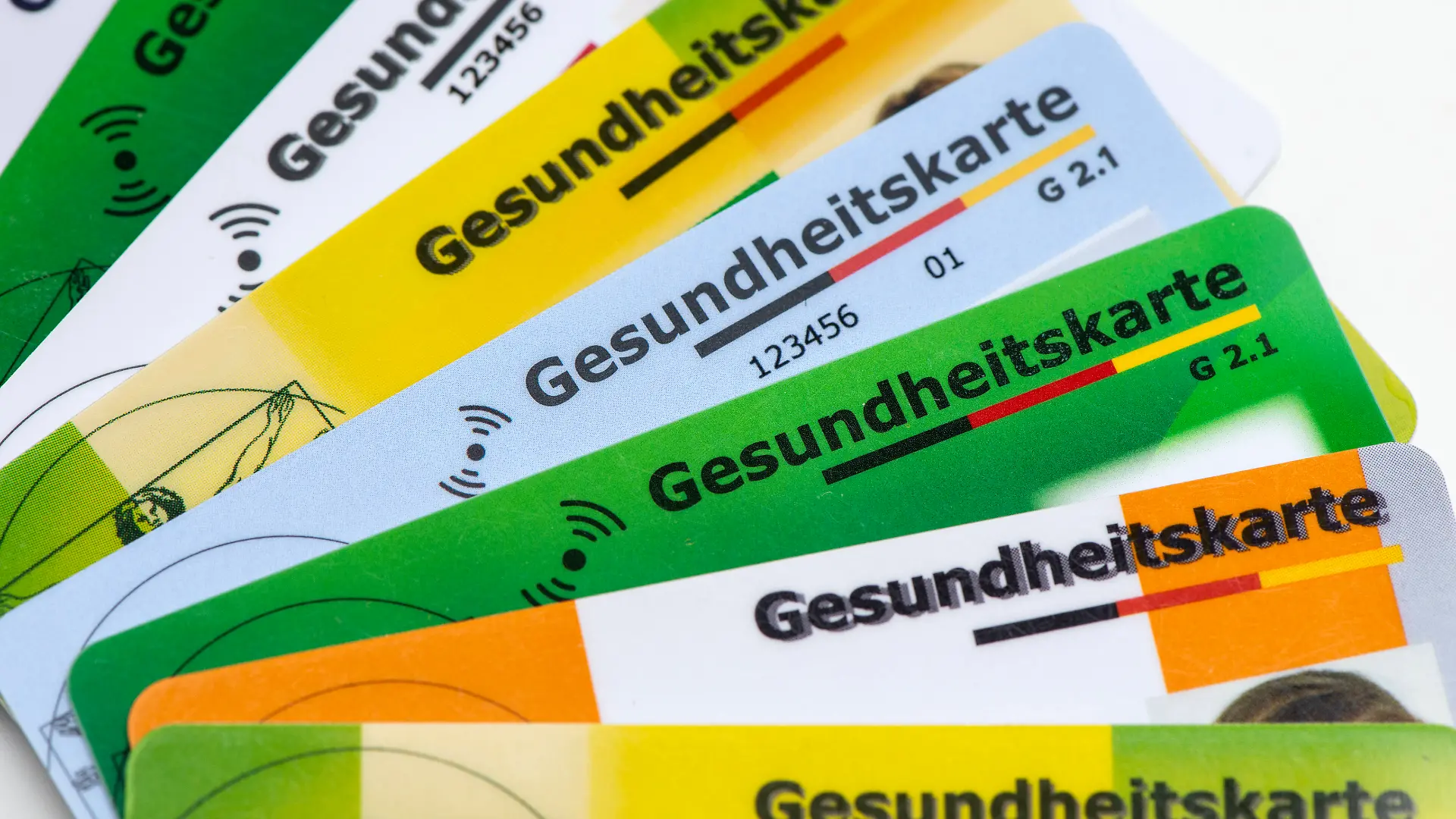 Verschiedene Gesundheitskarten von Krankenversicherungen liegen zusammen als Symbolbild für das Gesundheitssystem basierend auf gesetzlichen Krankenkassen - NUR FÜR REDAKTIONELLE VERWENDUNG -