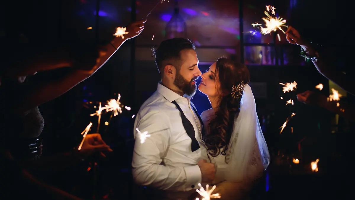 Ein Brautpaar tanzt im Dunkeln auf ihrer Hochzeit, um sie herum sind Wunderkerzen.