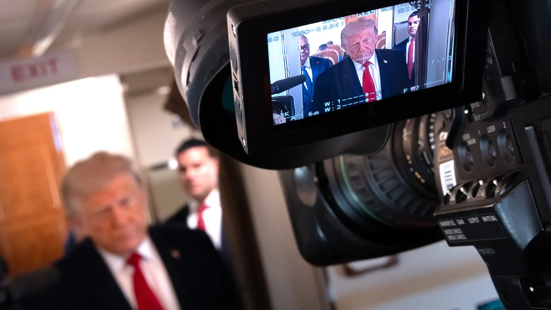 President Donald Trump is seen in a television camera's viewfinder as he speaks to reporters aboard Air Force One en route from Joint Base Andrews, Md., to Eau Claire, Wis., Friday, June 5, 2026. (AP Photo/Mark Schiefelbein)