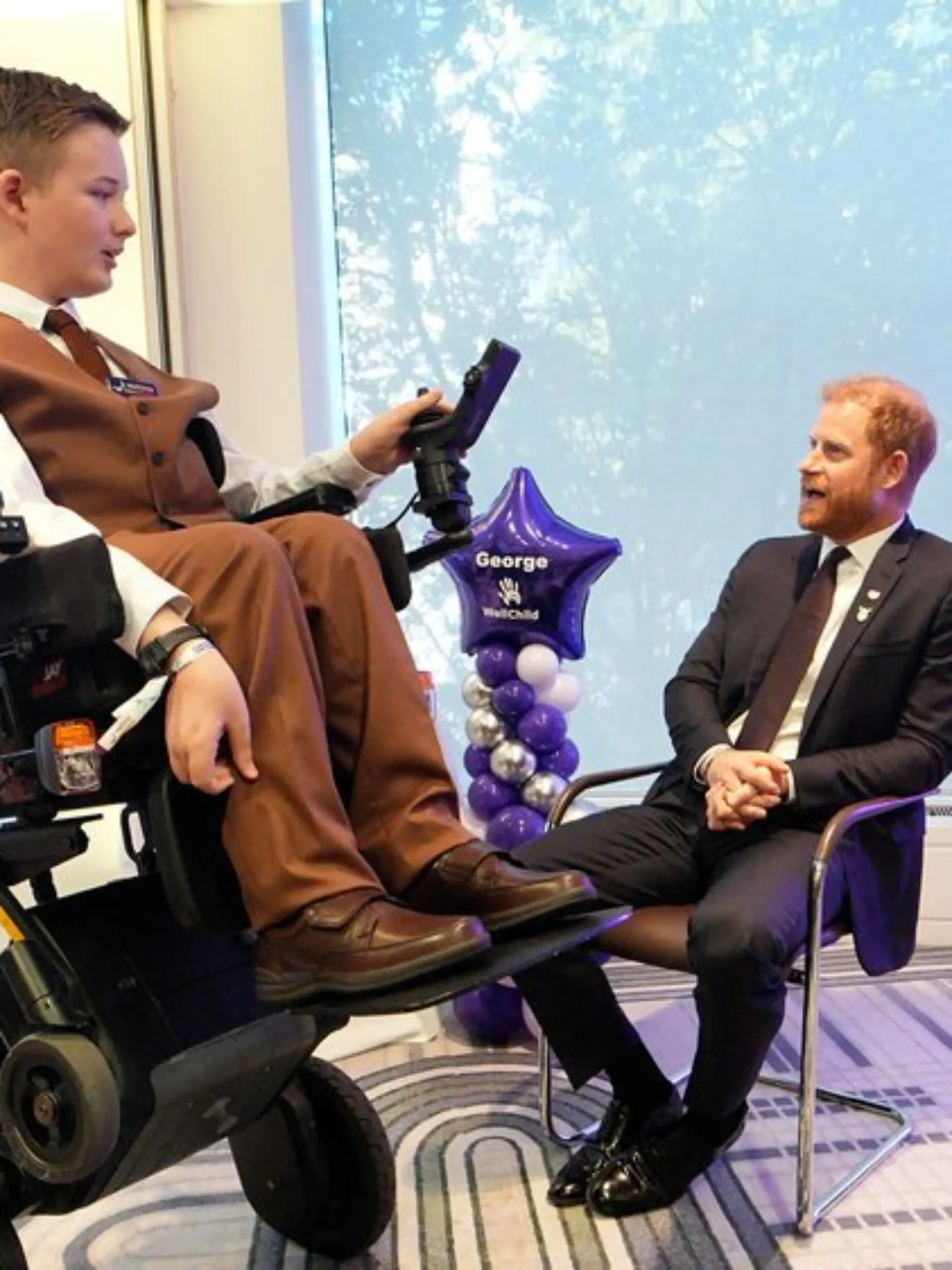 George, einer der jungen Gewinner, zeigt Harry seinen neuen Rollstuhl.