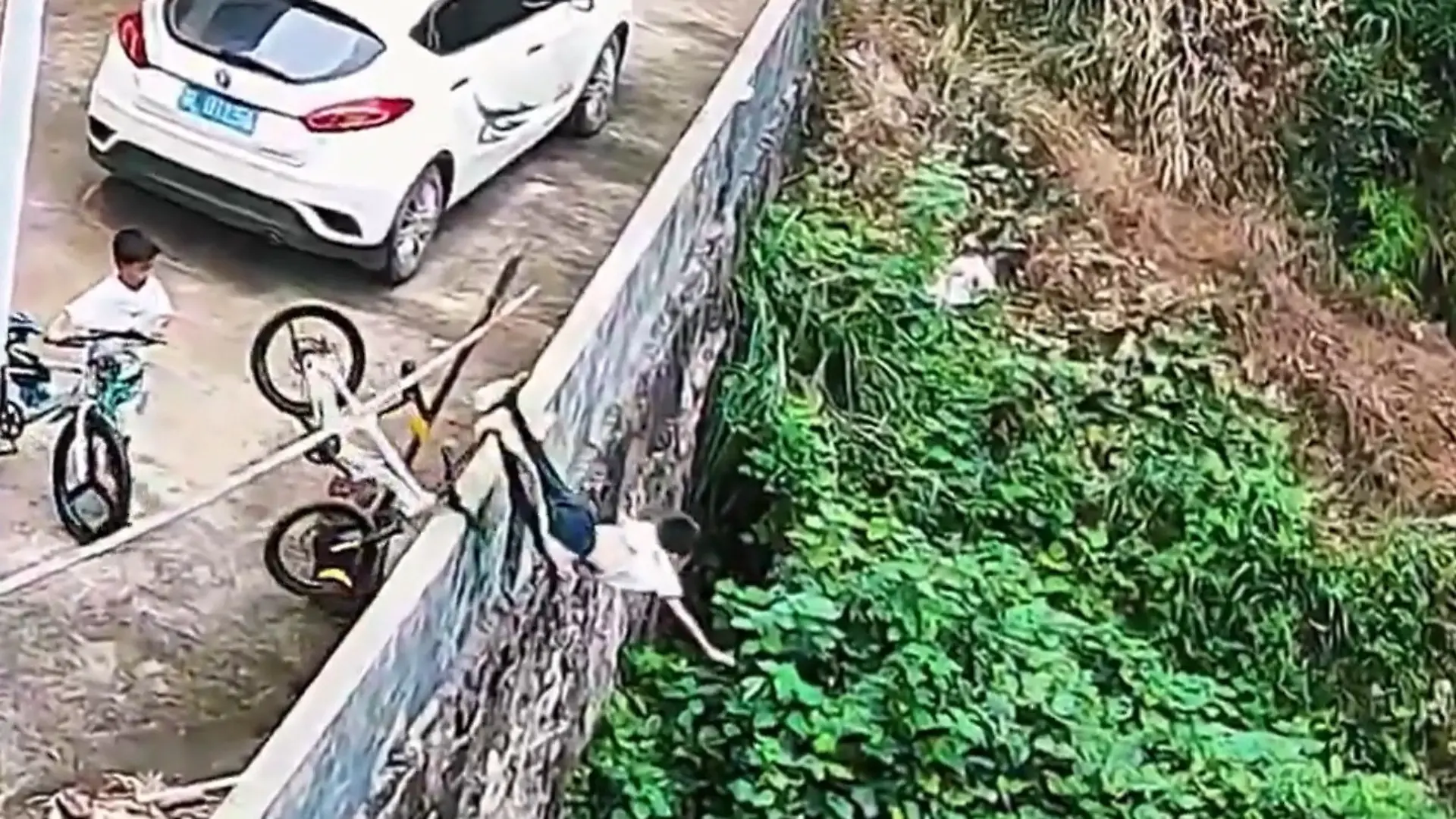 Junge fliegt mit Fahrrad über Mauer in den Abgrund – und steht einfach wieder auf! Unfall mit erstaunlichem Ende