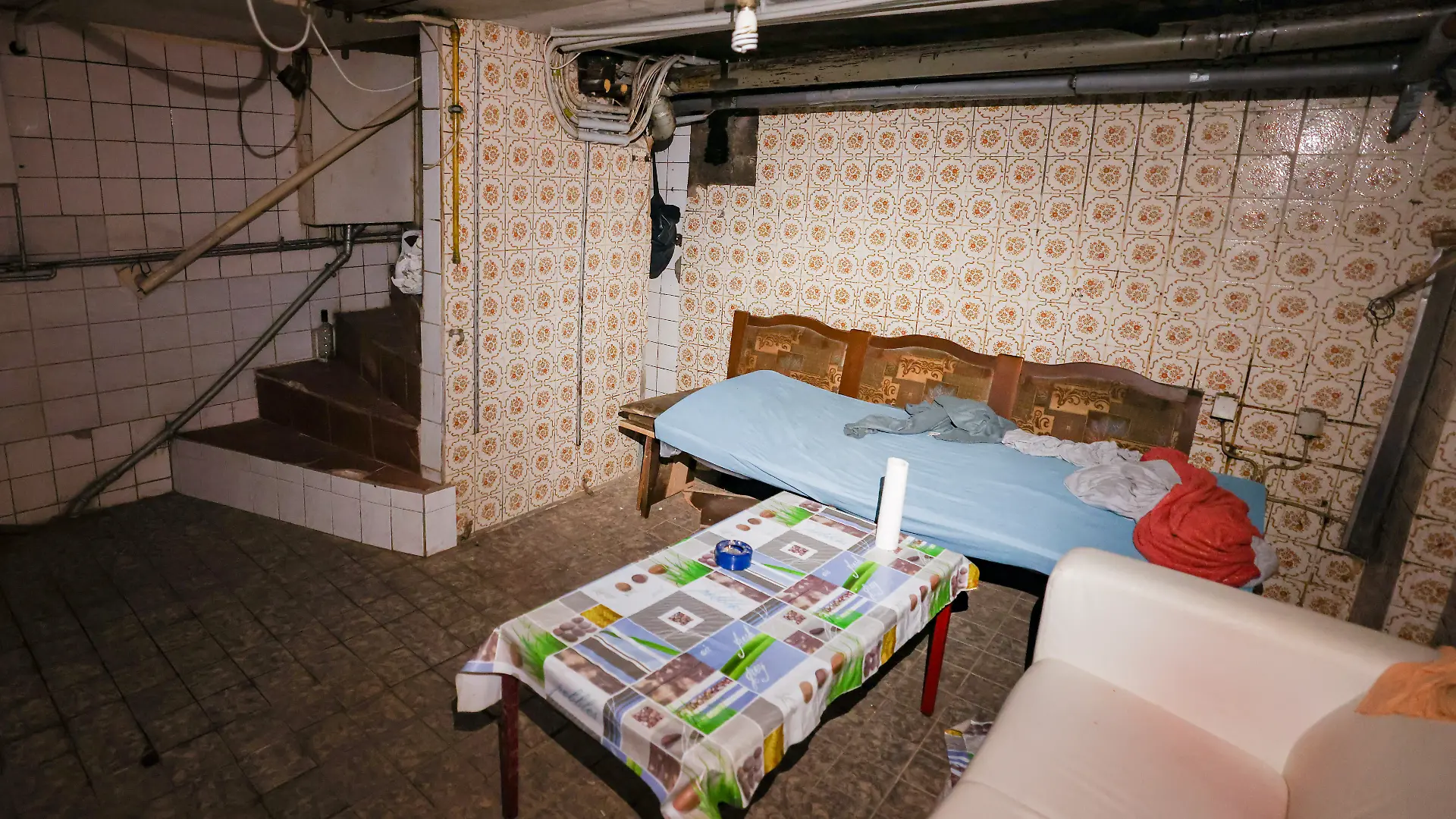 In einem Kellerraum einer Schrottimmobilie befinden sich mehrere provisorische Schlafplätze und ein Holztisch. Am Morgen fanden in mehreren nordrhein-westfälischen Städten Kontrollen im Kampf gegen kriminelle Geschäftsmodelle mit Schrottimmobilien und Sozialbetrug statt. Ziel der Kontrollen sei es, problematische Bau- und Wohnungsbestände, Sozialleistungsmissbrauch und ausbeuterische Verhältnisse aufzudecken. +++ dpa-Bildfunk +++