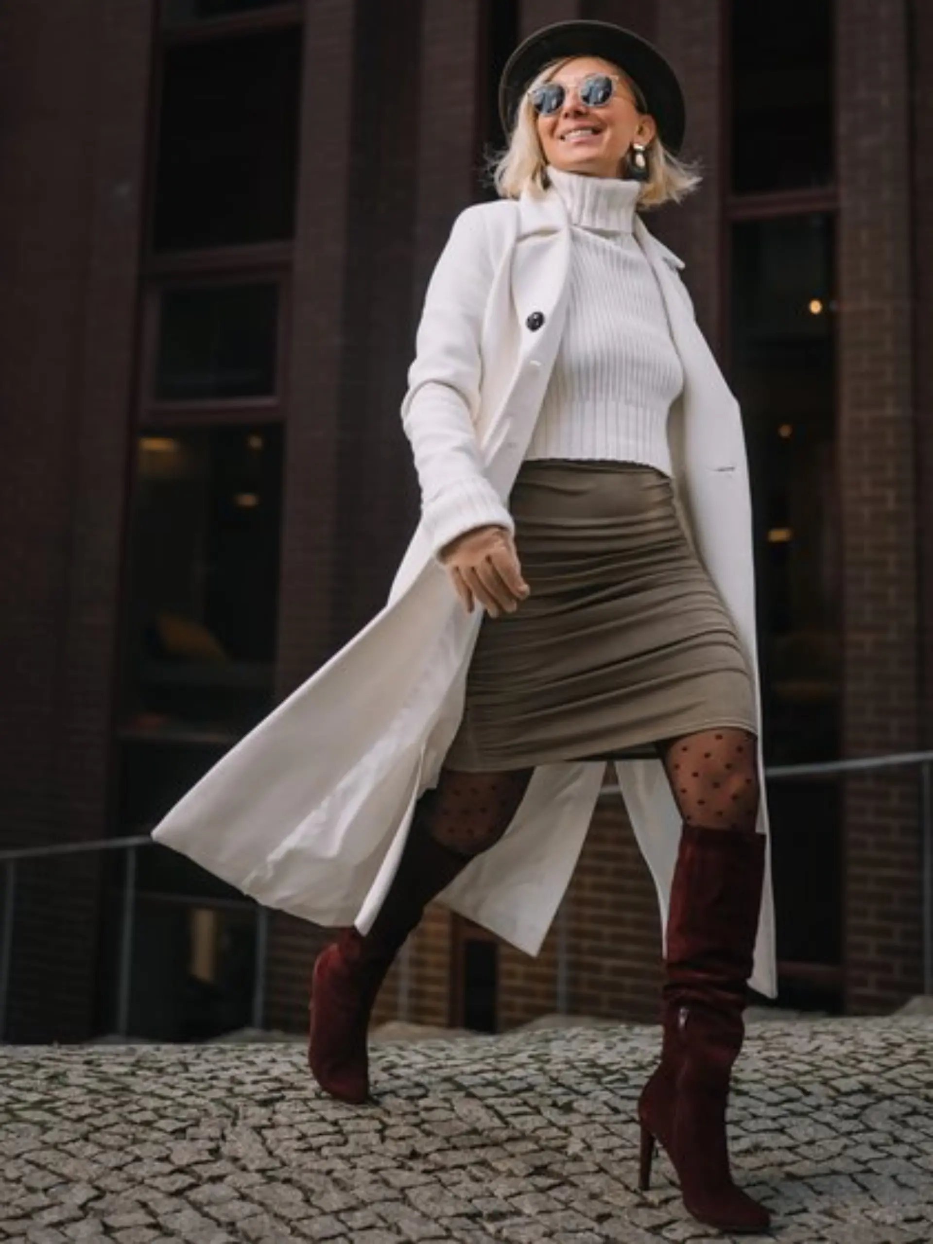 Ein Strickpulli wirkt mit einem Minirock und hohen Stiefeln gleich viel eleganter.