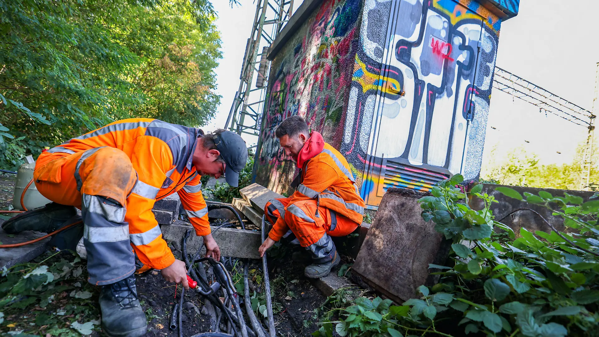 26.09.2026, Nordrhein-Westfalen, Gelsenkirchen: Mitarbeiter der Deutschen Bahn reparieren in Gelsenkirchen die beschädigten Kabel neben einer Bahnstrecke. Die Polizei ermittelt wegen mutmaßlichen Kabeldiebstahls entlang einer Bahnstrecke im Stadtteil Gelsenkirchen-Ückendorf, sagte ein Sprecher der Polizei. In der Folge seien Signale und Steuerungsanlagen ausgefallen. Der gesamte Großraum Gelsenkirchen sei aktuell nicht befahrbar, heißt es auf dem Infoportal Zuginfo.nrw. Foto: Christoph Reichwein/dpa +++ dpa-Bildfunk +++