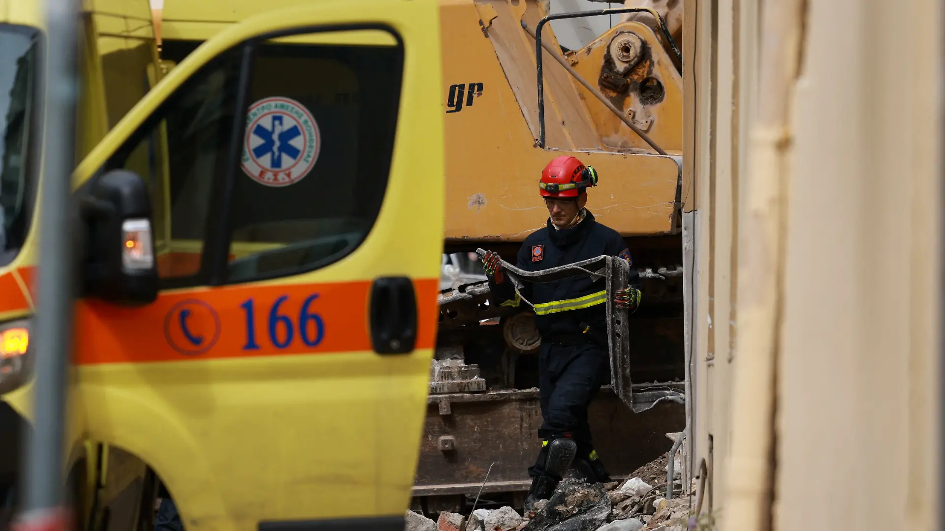 A member of emergency personnel inspects a piece of metal during a search and rescue operation after a building partially collapsed following an explosion in the Plaka area, which is popular with tourists, in central Athens, Greece, September 26, 2026. REUTERS/Stelios Misinas