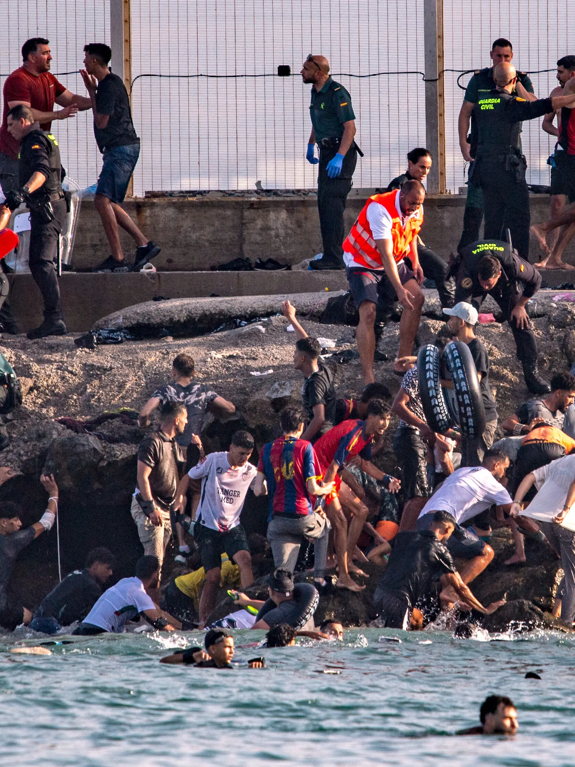 Migrants try to cross from Morocco into the Spanish enclave of Ceuta, Thursday, July 30, 2026. (AP Photo/Antonio Sempere)