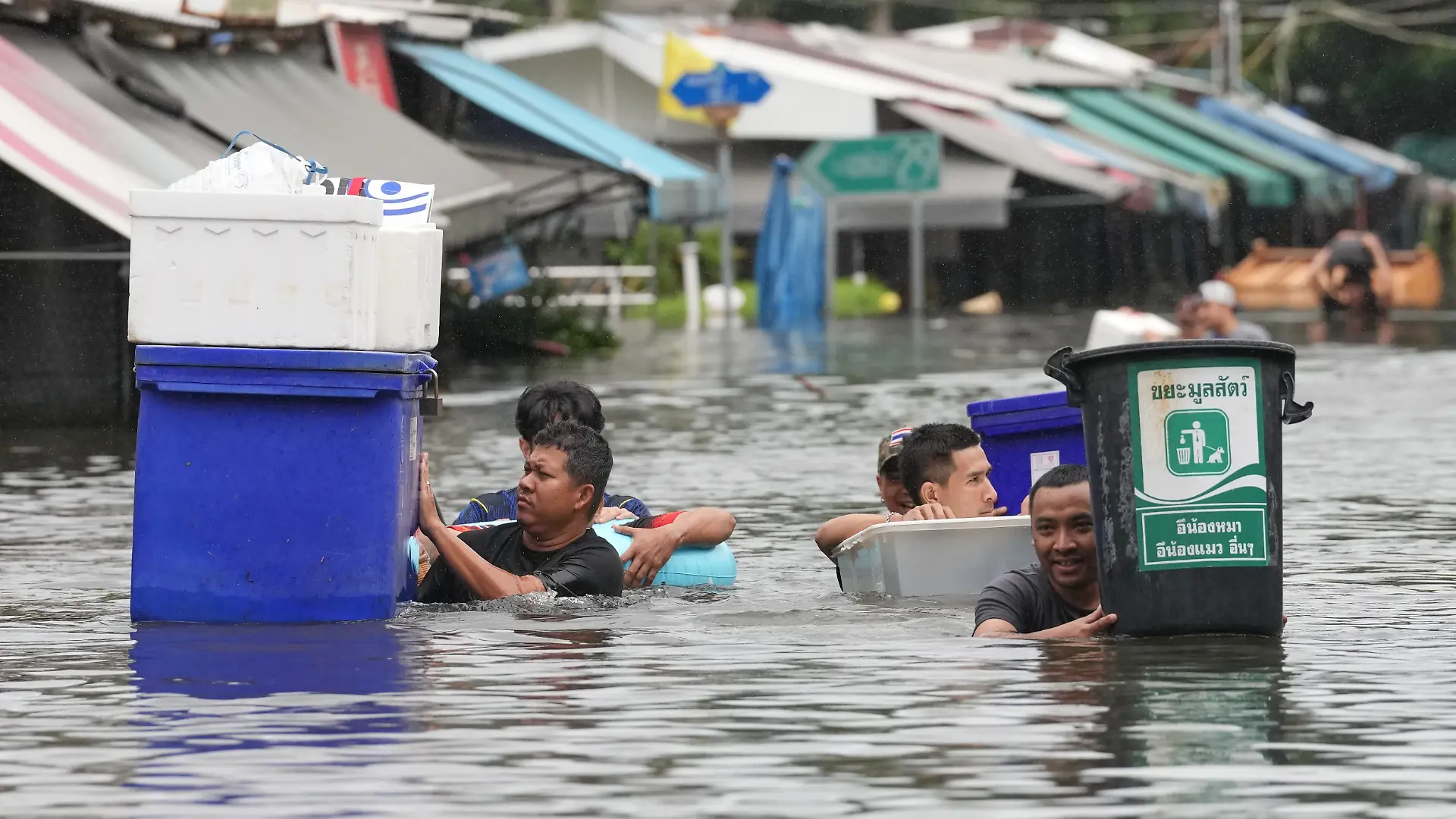 Nach starken Regenfällen waten Menschen in Bangkok durch das Wasser. +++ dpa-Bildfunk +++