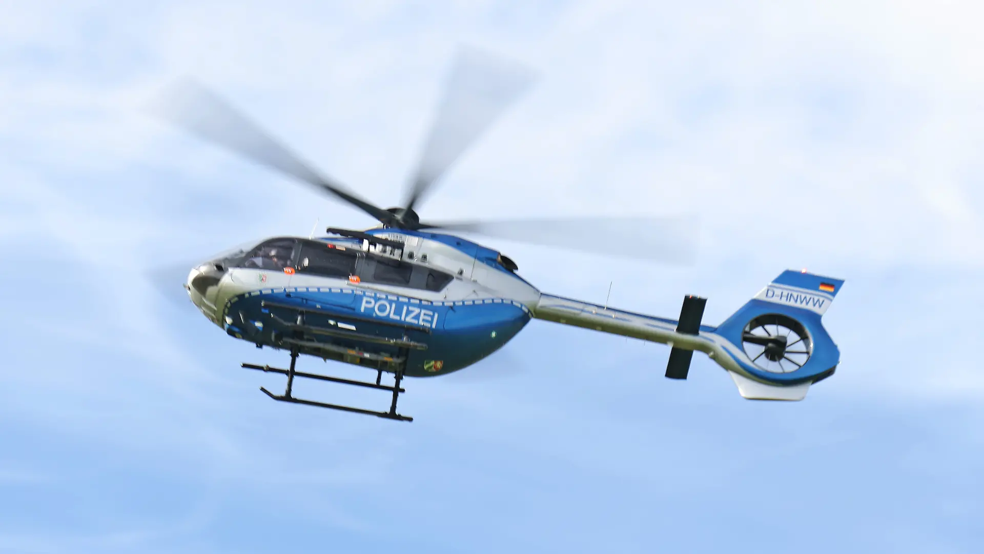23.09.2026, Wirtschaft v.l. Auf diesem Foto ist ein Polizeihubschrauber der Polizei Nordrhein-Westfalen mit der Kennung D-HNWI im Flug zu sehen. Das Bild kann symbolisch für Polizeieinsätze aus der Luft, Überwachung und Lagebeobachtung, Fahndungsmaßnahmen, Verkehrskontrollen sowie die öffentliche Sicherheit in Nordrhein-Westfalen stehen.