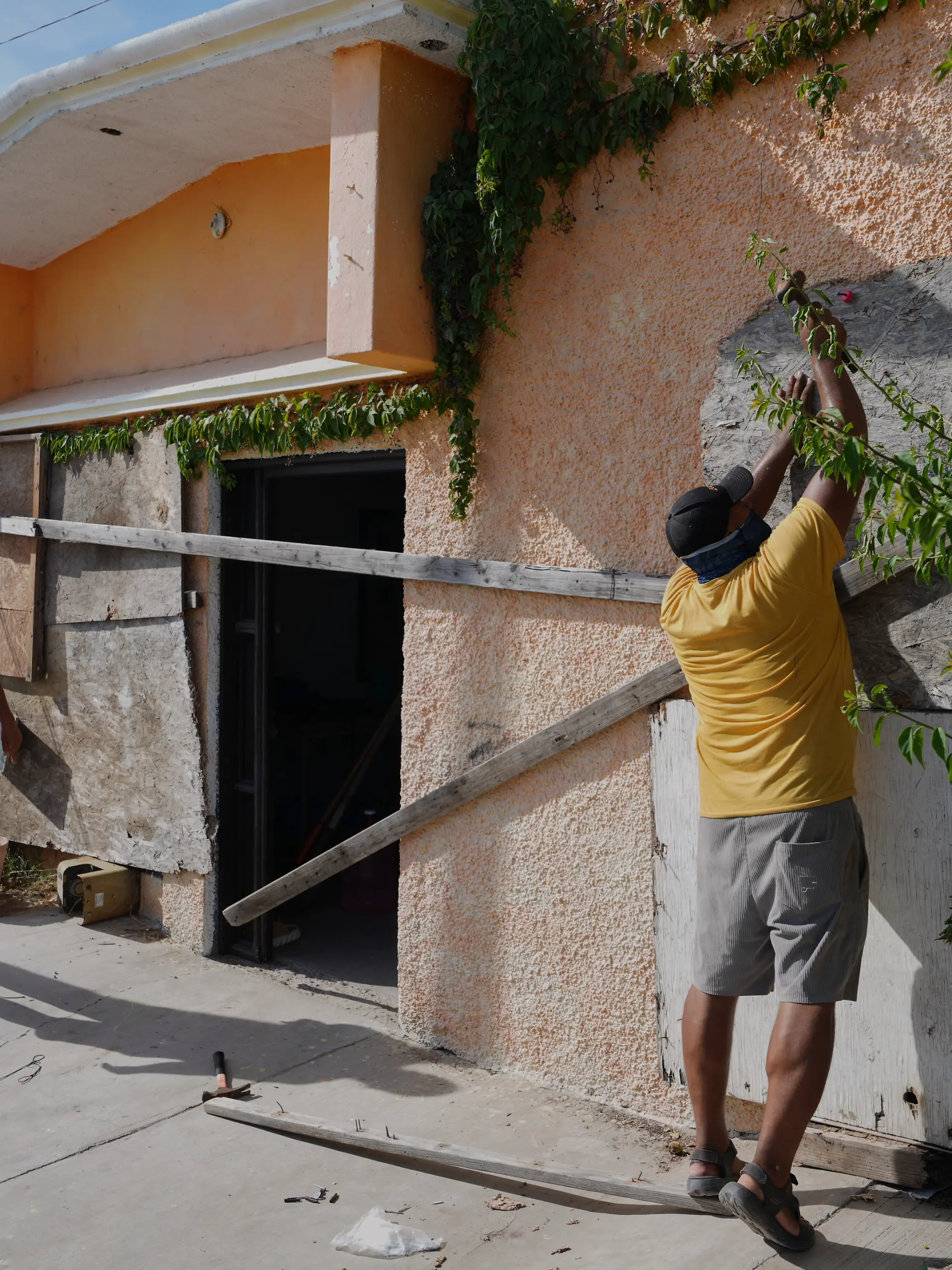 Ein Mann vernagelt die Fenster eines Hauses, während sich der Hurrikan Polo in Puerto San Carlos im mexikanischen Bundesstaat Baja California Sur nähert. +++ dpa-Bildfunk +++