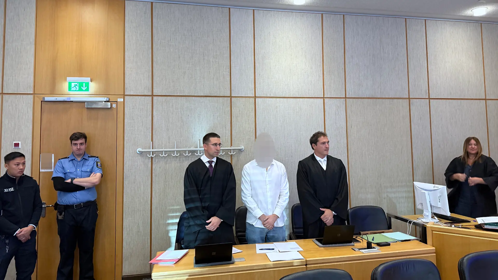 Der Angeklagte (M), sein Pflichtverteidiger Yannic Hübner (l) und Verteidiger Maurice Weidhaas warten im Landgericht Frankfurt auf den Prozessbeginn.