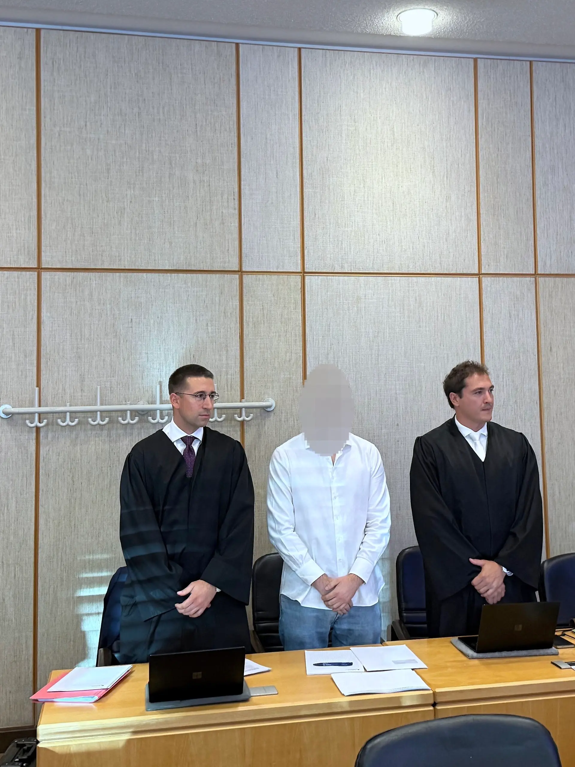 Der Angeklagte (M), sein Pflichtverteidiger Yannic Hübner (l) und Verteidiger Maurice Weidhaas warten im Landgericht Frankfurt auf den Prozessbeginn.