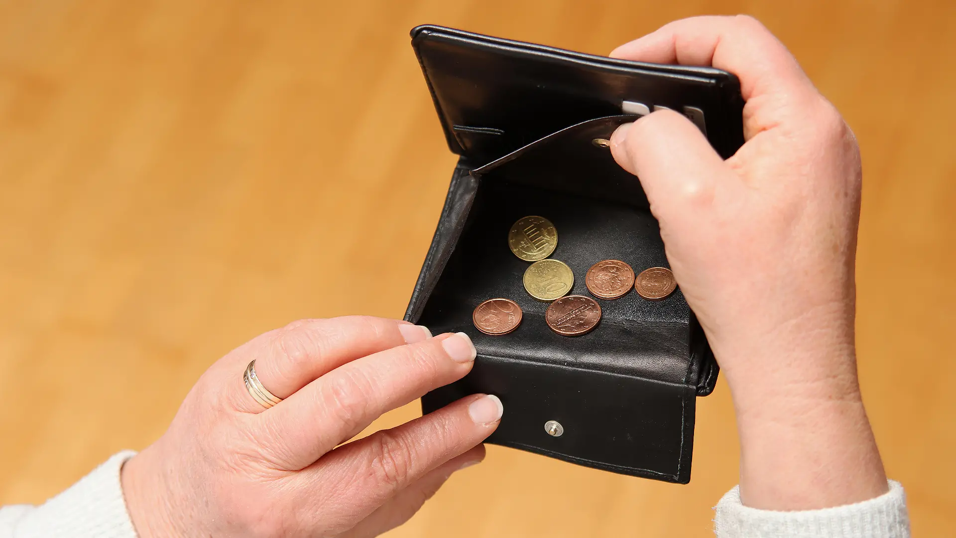 Frau zeigt ihr leeres Portemonnaie