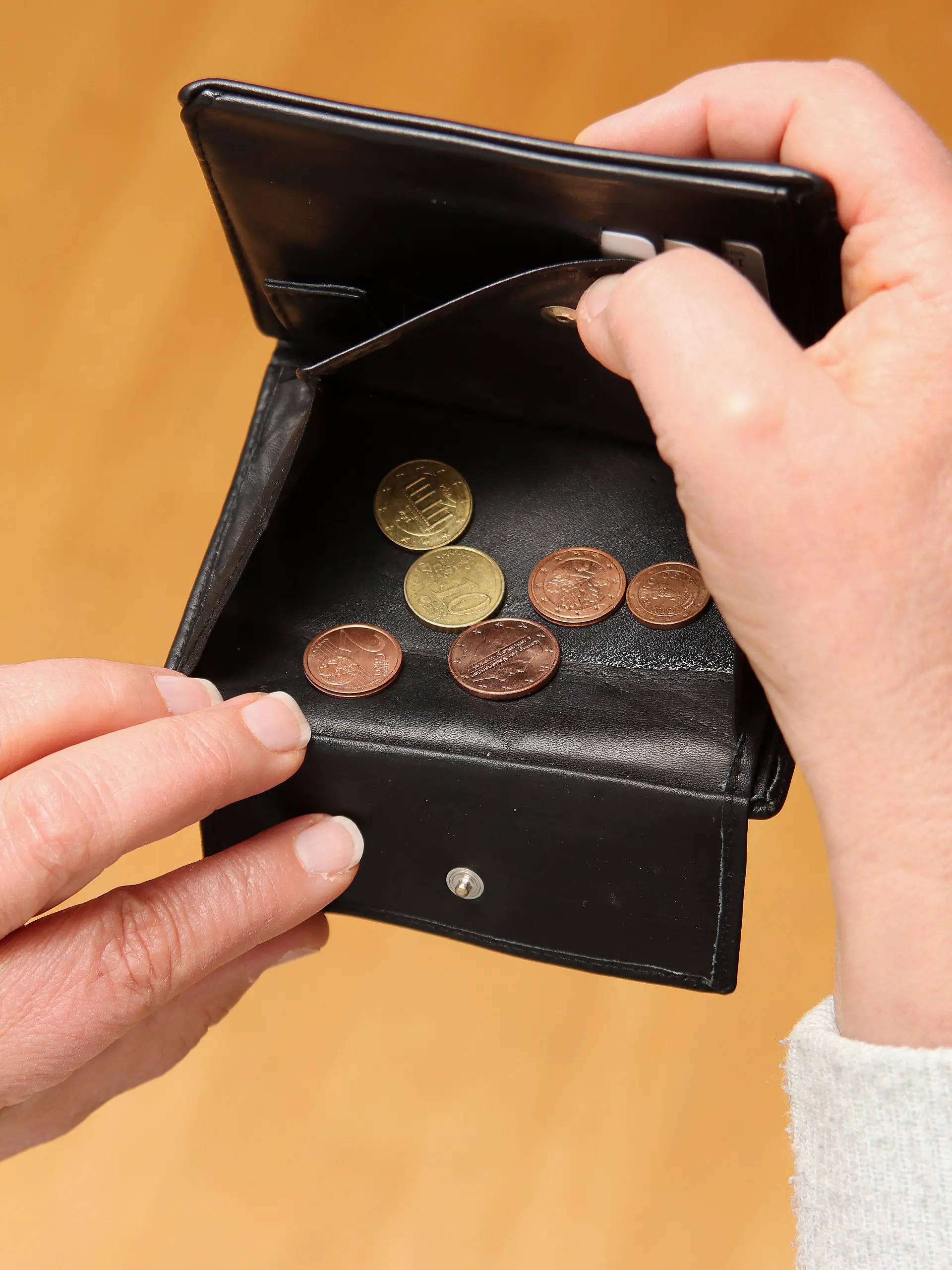 Frau zeigt ihr leeres Portemonnaie