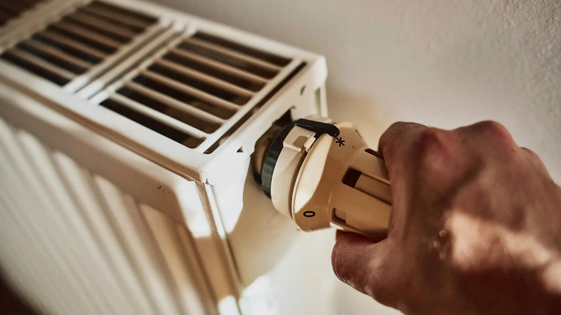 Augsburg, Bavaria, Germany - April 13, 2024: A man s hand turns the thermostat on a radiator. Heating *** Die Hand von einem Mann dreht am Thermostat von einem Heizkörper. Heizung