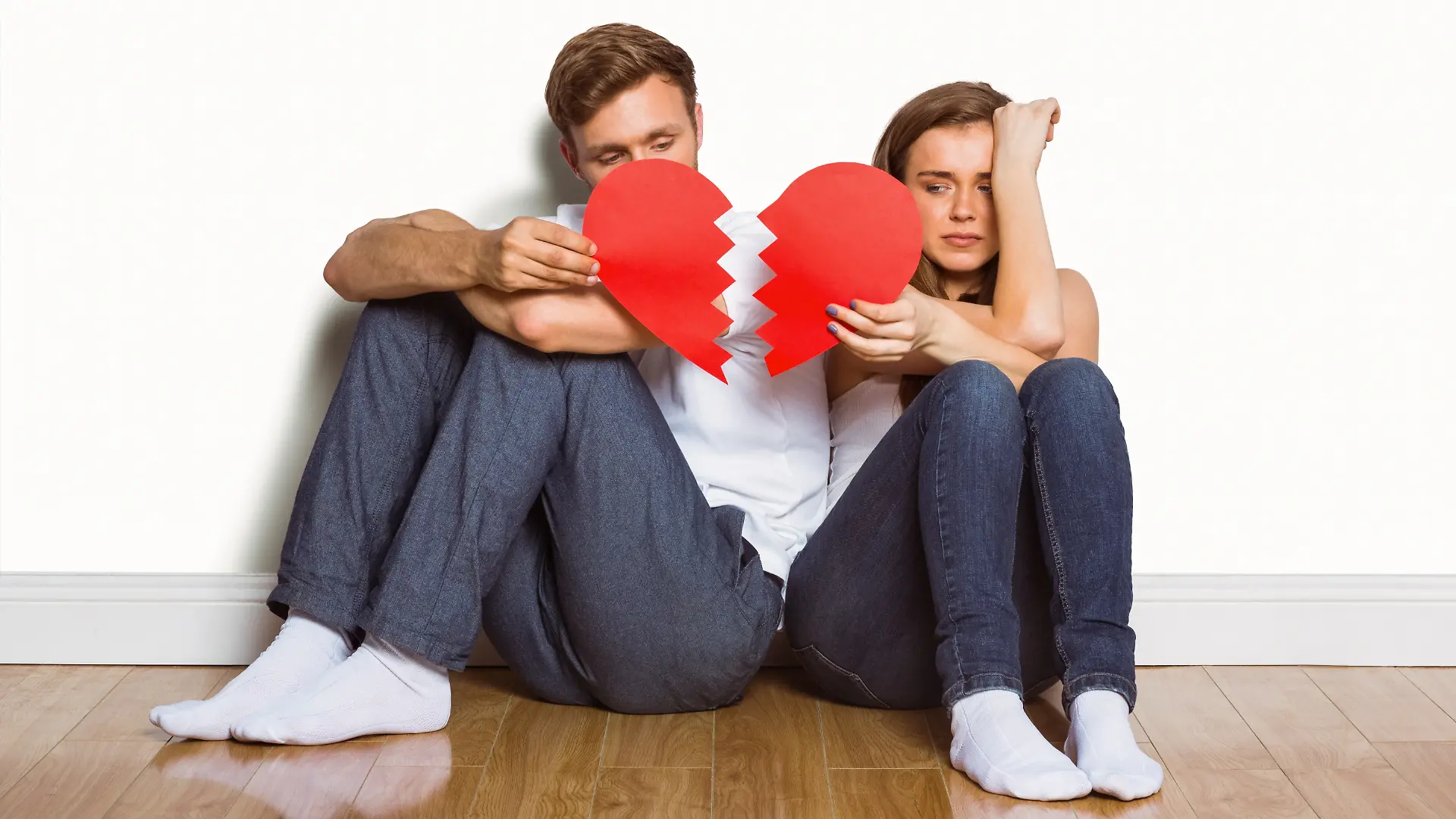 Young couple holding broken heart