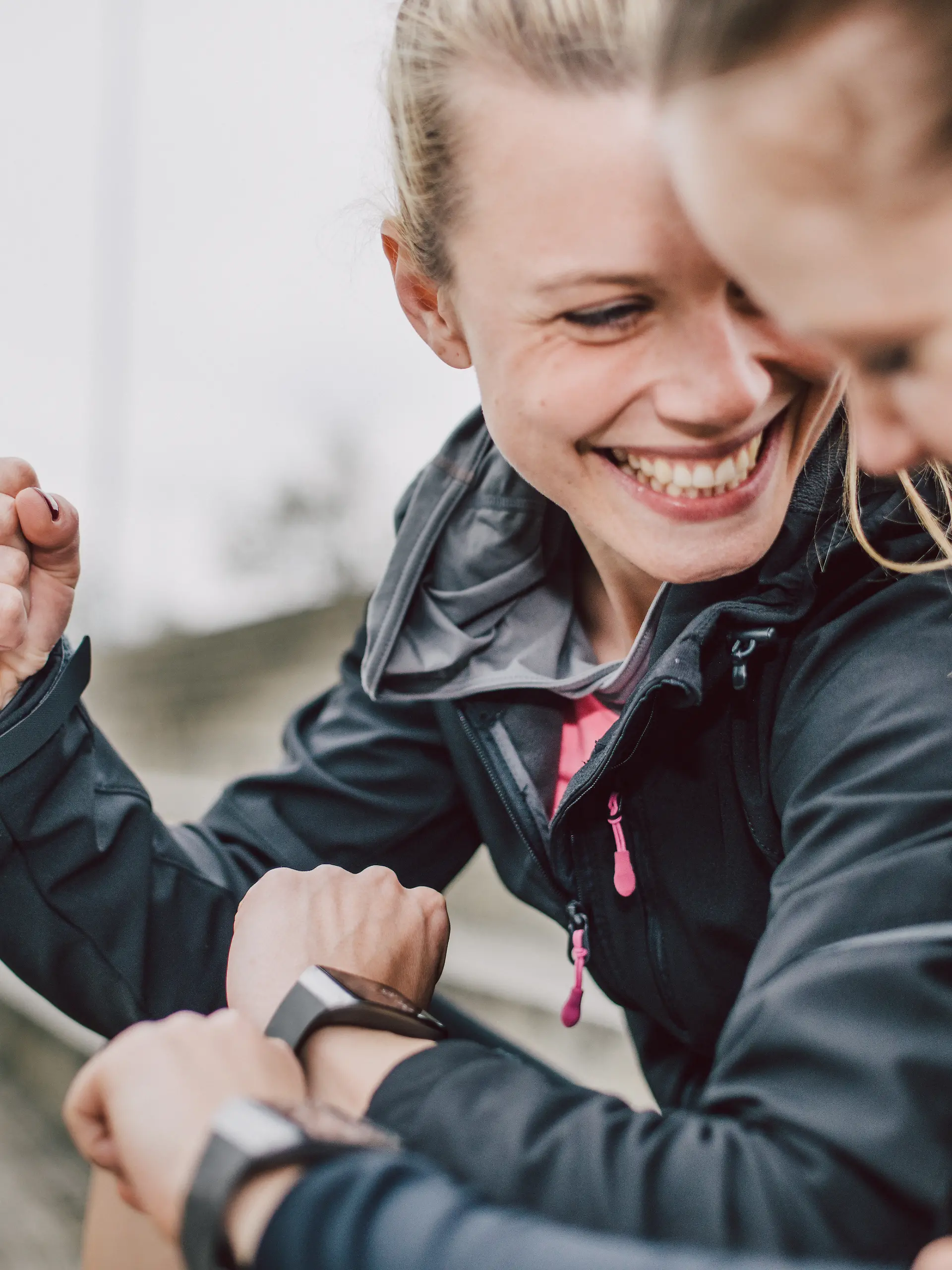 Freundinnen, die nach dem Sport über ihre Smartwatch ihre Daten vergleichen