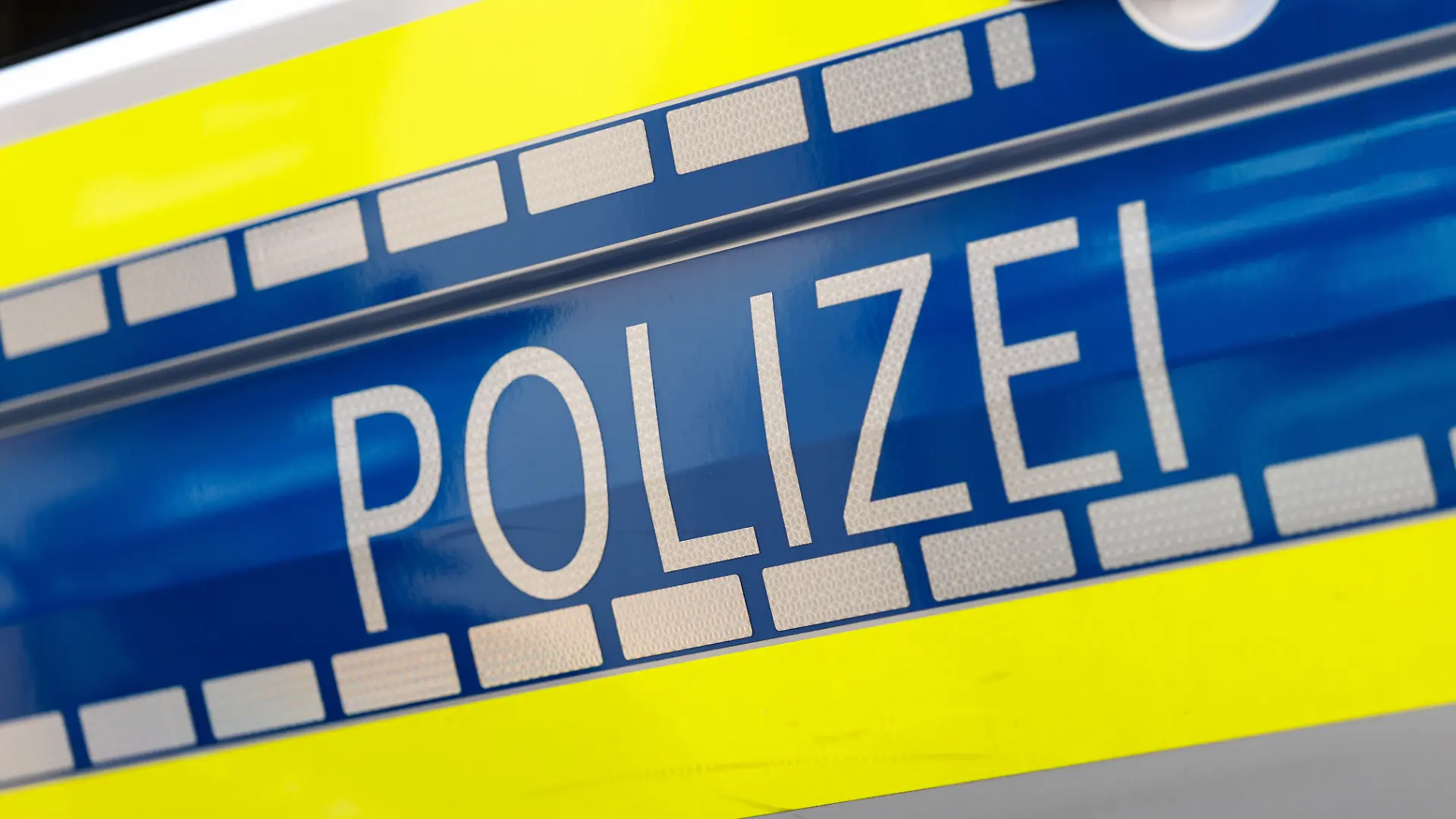 Der Schriftzug Polizei ist an einem Einsatzfahrzeug der Polizei