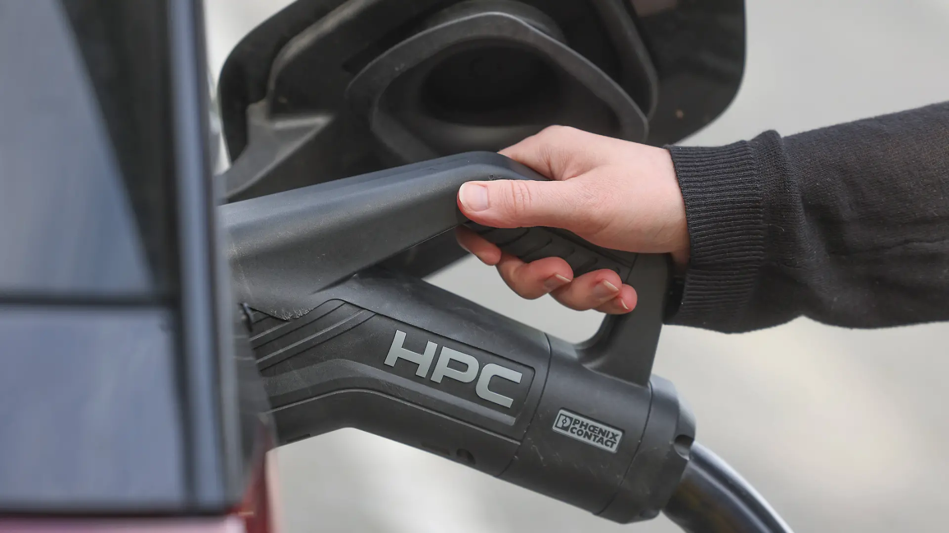 Ein Elektrofahrzeug wird an der Raststaette Raststätte Siegerland West geladen. Das Ladekabel steckt im Stecker am Auto. Eine Hand, Frauenhand am Griff. Elektromobilitaet Elektromobilität am 19.09.2026 in Siegen/Deutschland. *** An electric vehicle is being charged at the Siegerland West rest stop. The charging cable is plugged into the car. A handa woman s handis on the handle. Electric mobility on September 19, 2026, in Siegen, Germany