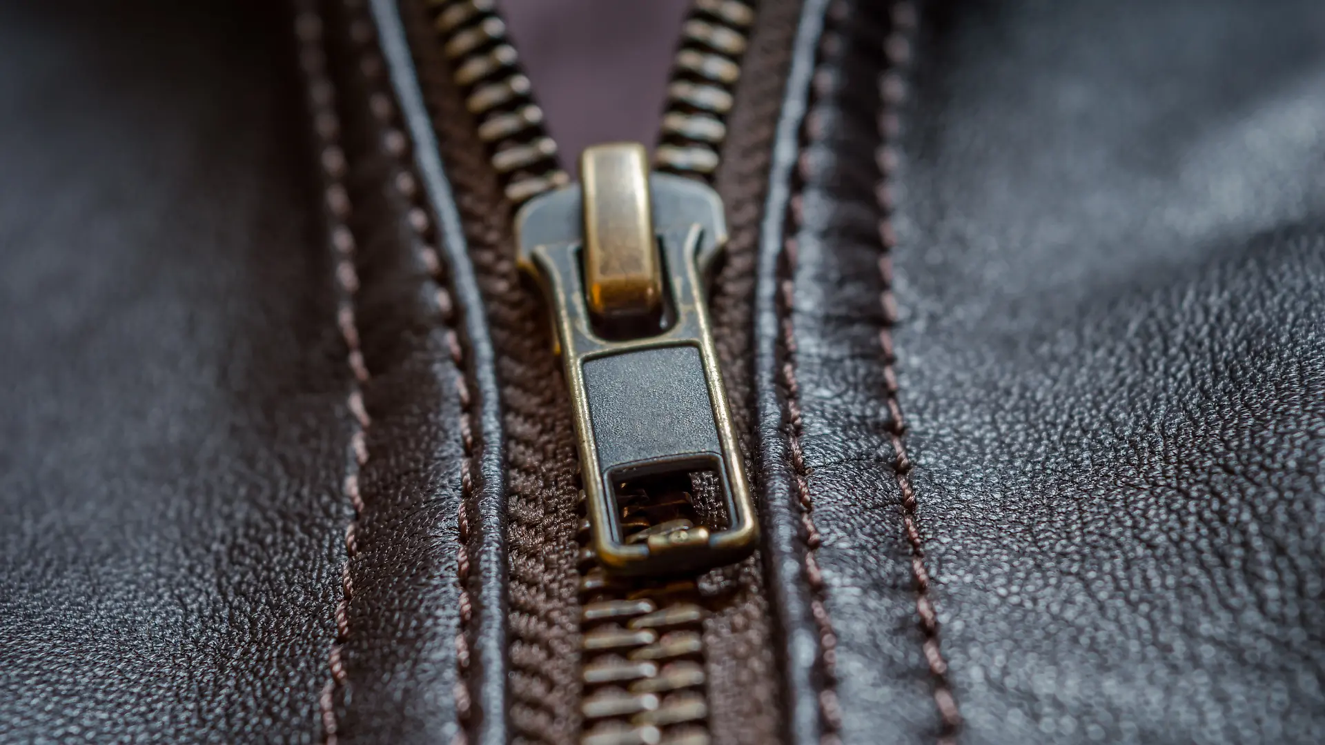 Close-up des Reißverschlusses einer dunkelbraunen Lederjacke 
