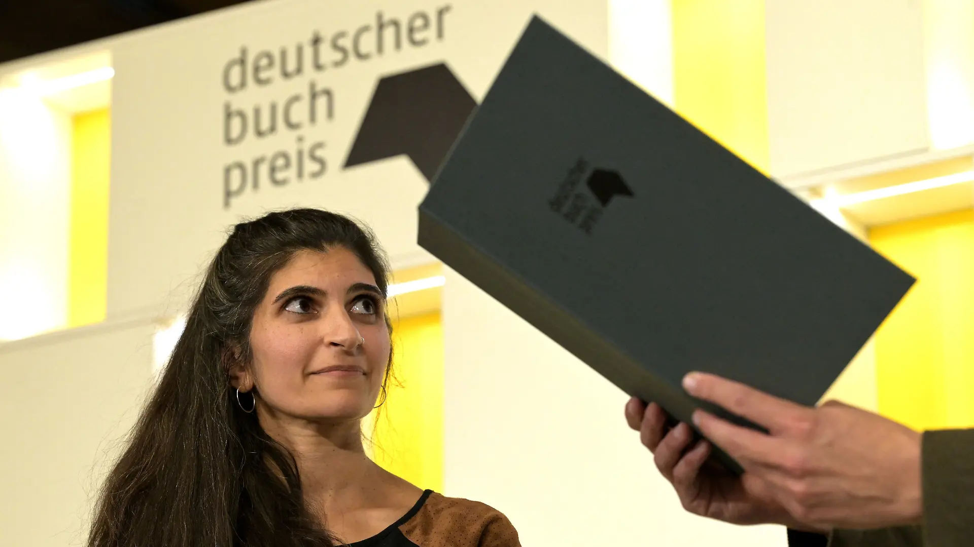05.10.2026, Hessen, Frankfurt/Main: Die Autorin Shida Bazyar nimmt den Deutschen Buchpreis entgegen. Der Deutsche Buchpreis geht in diesem Jahr an Shida Bazyar für ihren Roman «Die Lücken». Das gab der Börsenverein des Deutschen Buchhandels in Frankfurt bekannt. Foto: Hannes P. Albert/dpa +++ dpa-Bildfunk +++