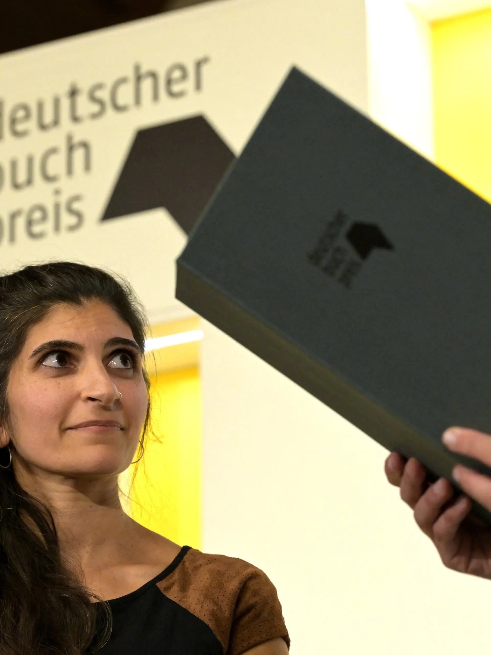 05.10.2026, Hessen, Frankfurt/Main: Die Autorin Shida Bazyar nimmt den Deutschen Buchpreis entgegen. Der Deutsche Buchpreis geht in diesem Jahr an Shida Bazyar für ihren Roman «Die Lücken». Das gab der Börsenverein des Deutschen Buchhandels in Frankfurt bekannt. Foto: Hannes P. Albert/dpa +++ dpa-Bildfunk +++