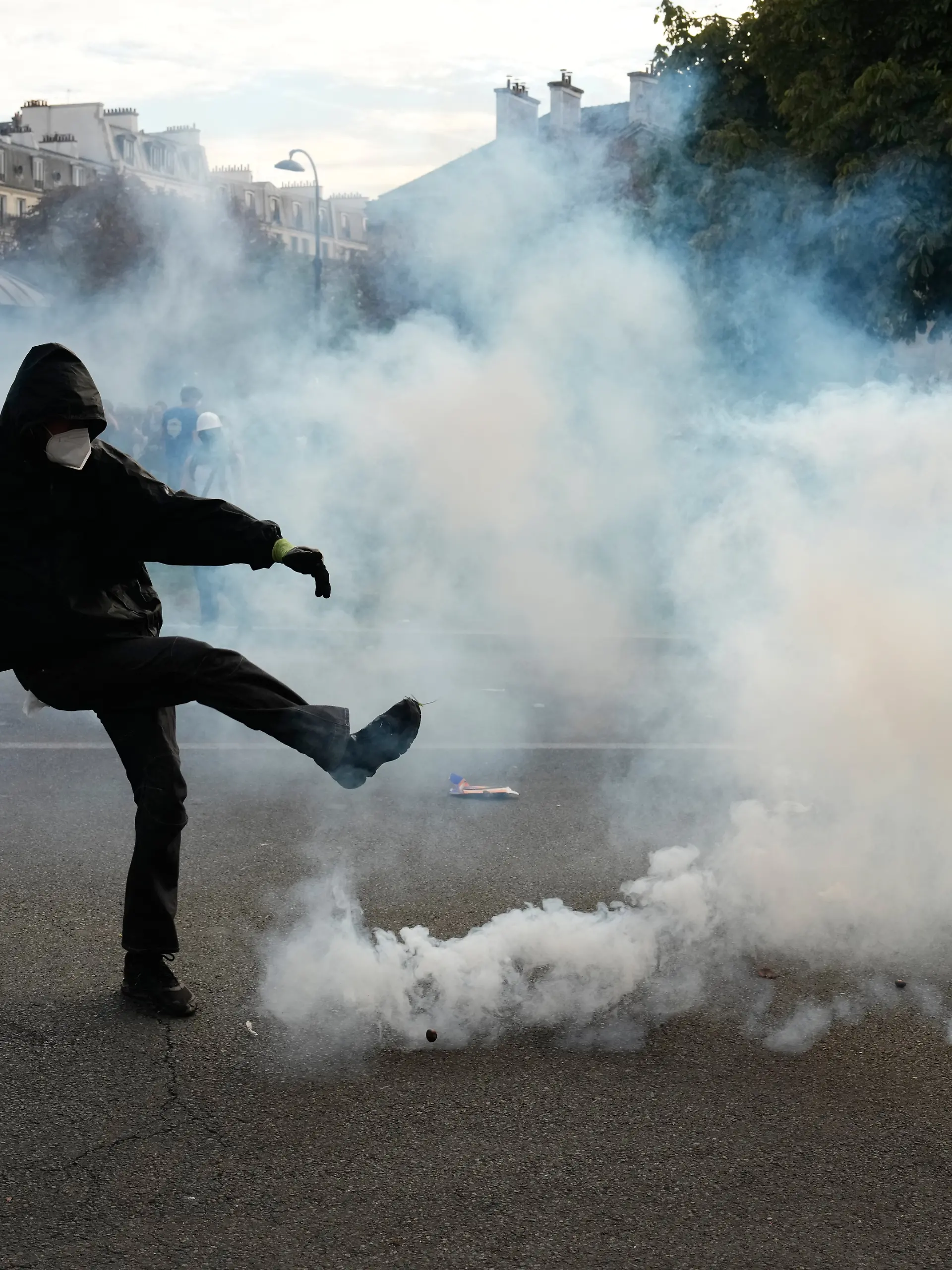 Ein Demonstrant tritt während Ausschreitungen im Anschluss an eine Demonstration gegen unterfinanzierte Schulen gegen eine Tränengasgranate. +++ dpa-Bildfunk +++