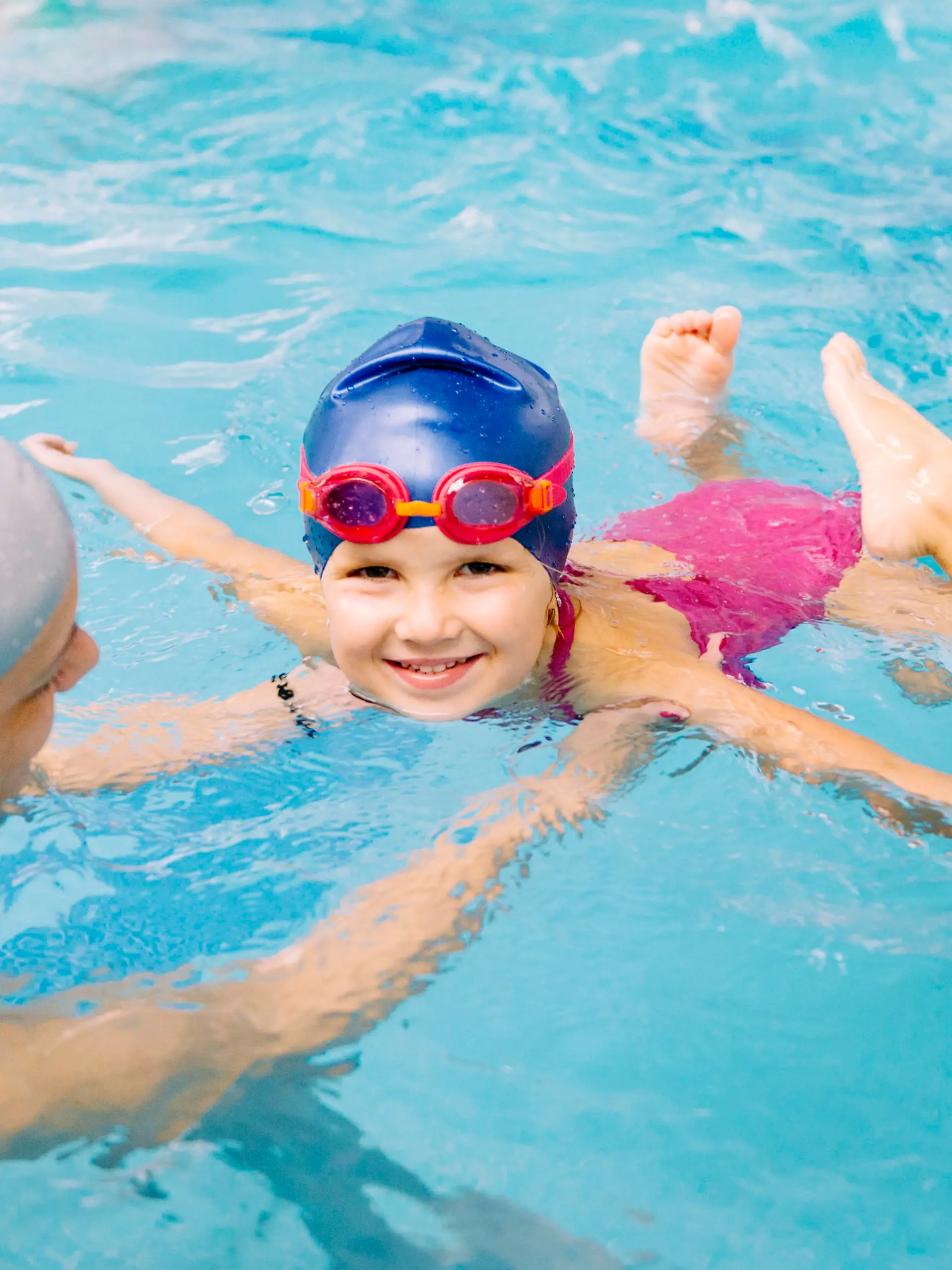 Swimming class - little girl learning to swim with swimming  instructor