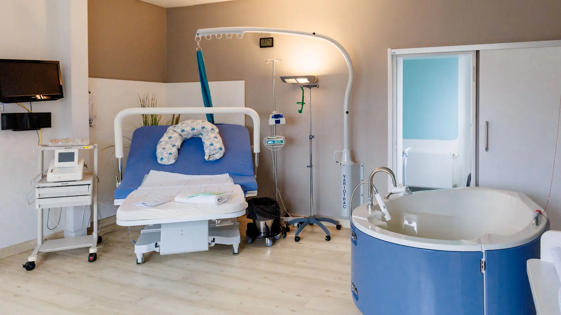 Blick in einen Kreißsaal mit Kreißbett und Geburtswanne.