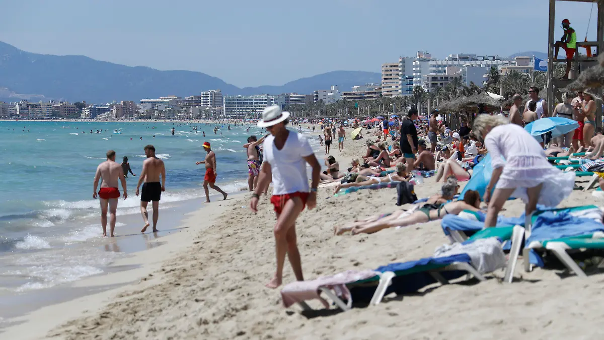 26.06.2021, Spanien, Palma de Mallorca: Touristen halten sich am Strand von Arenal in Palma de Mallorca auf. Die Maskenpflicht wurde in Spanien erheblich gelockert. Mund-Nasen-Schutz muss im Freien nicht mehr immer und überall getragen werden. Foto: Clara Margais/dpa +++ dpa-Bildfunk +++