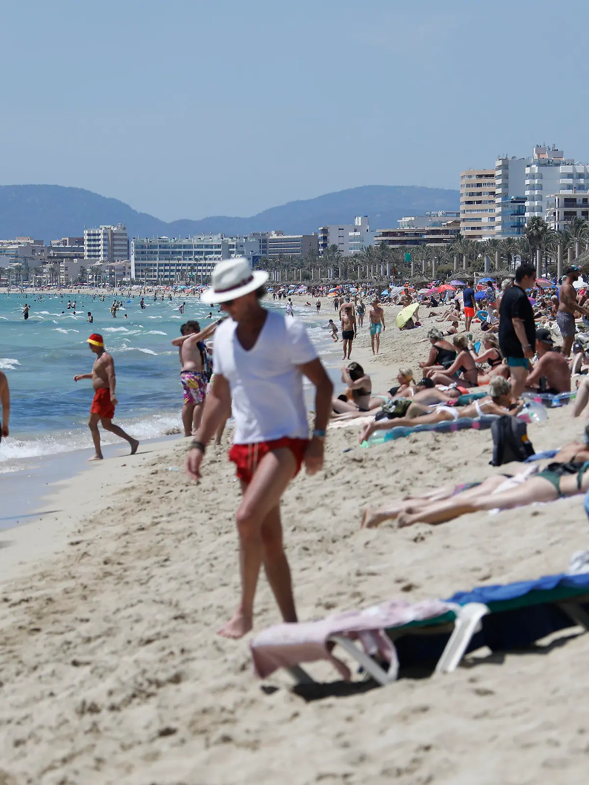 26.06.2021, Spanien, Palma de Mallorca: Touristen halten sich am Strand von Arenal in Palma de Mallorca auf. Die Maskenpflicht wurde in Spanien erheblich gelockert. Mund-Nasen-Schutz muss im Freien nicht mehr immer und überall getragen werden. Foto: Clara Margais/dpa +++ dpa-Bildfunk +++