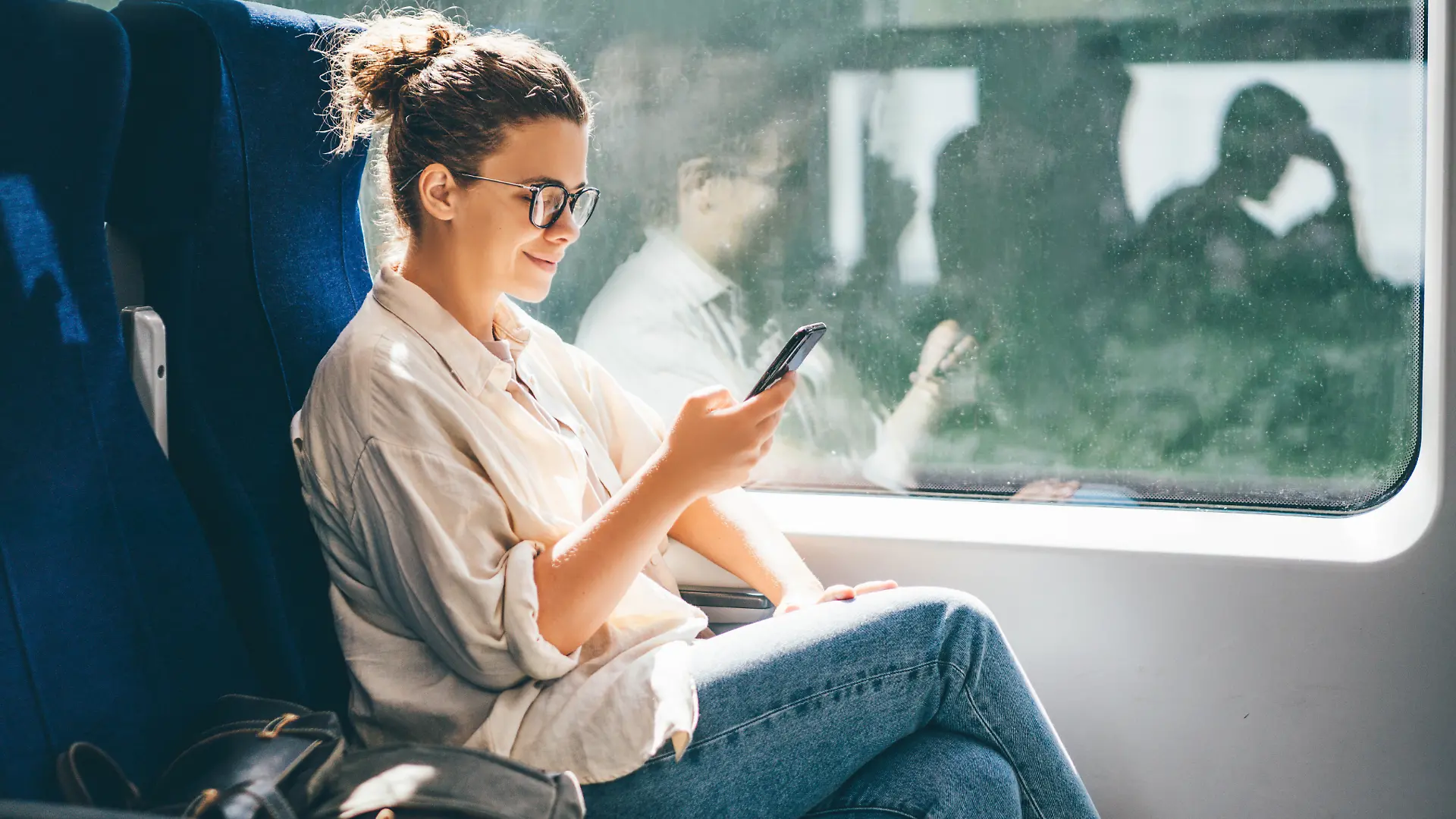 Frau am Handy in der Bahn.