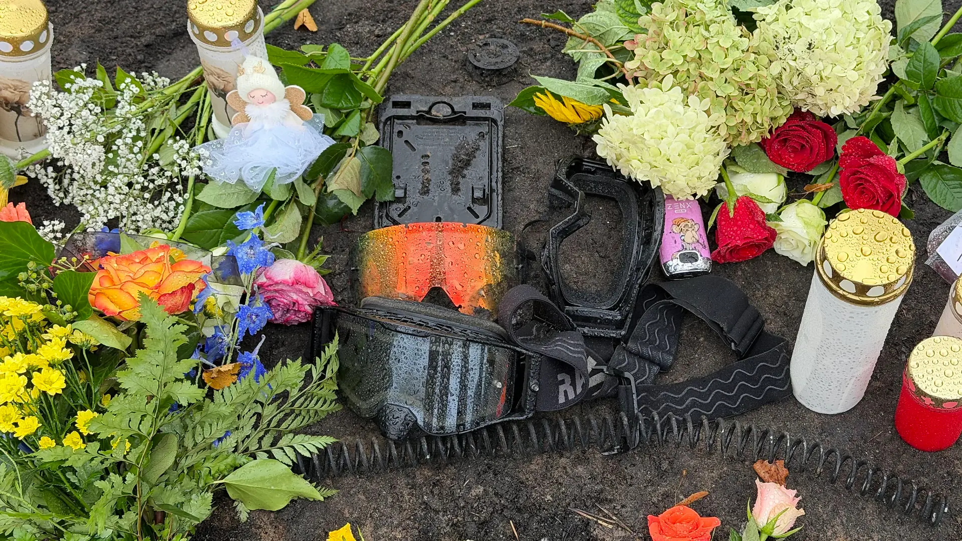 Zwischen Blumen und Grablichtern liegen eine Schutzbrille und Fahrzeugteile – persönliche Erinnerungsstücke, mit denen Trauernde der vier jungen Todesopfer von Biesenthal gedenken.