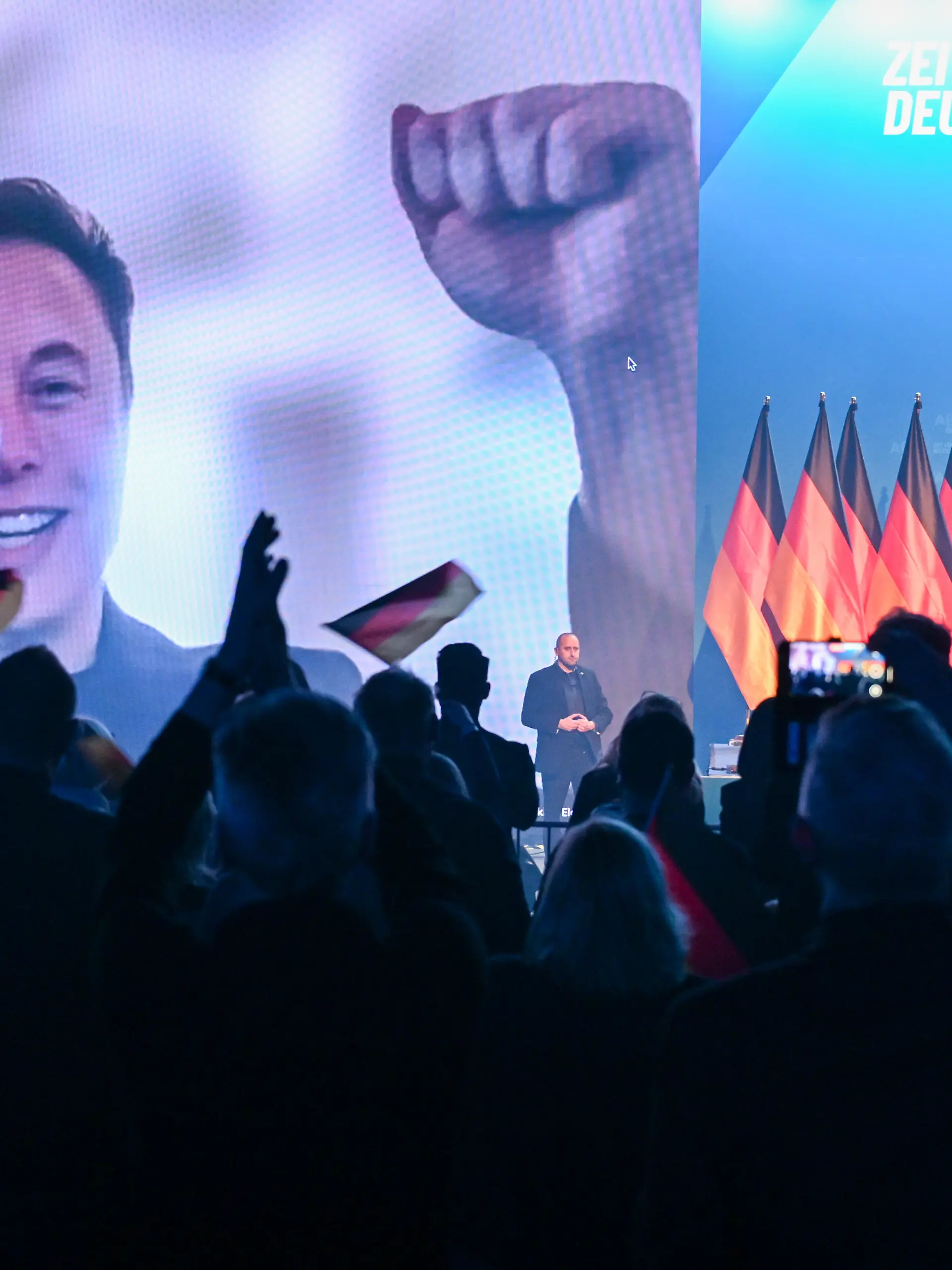 Über eine Videoeinblendung unterhält sich US-Miliardär Elon Musk mit Alice Weidel (r), Bundesvorsitzende der AfD, beim Wahlkampfauftakt der AfD. Am 23.02.2025 sind rund 59 Millionen Bundesbürger aufgerufen, einen neuen Bundestag zu wählen. (zu dpa: «Brandenburger kritisieren Elon Musk für AfD-Wahlkampfhilfe») +++ dpa-Bildfunk +++