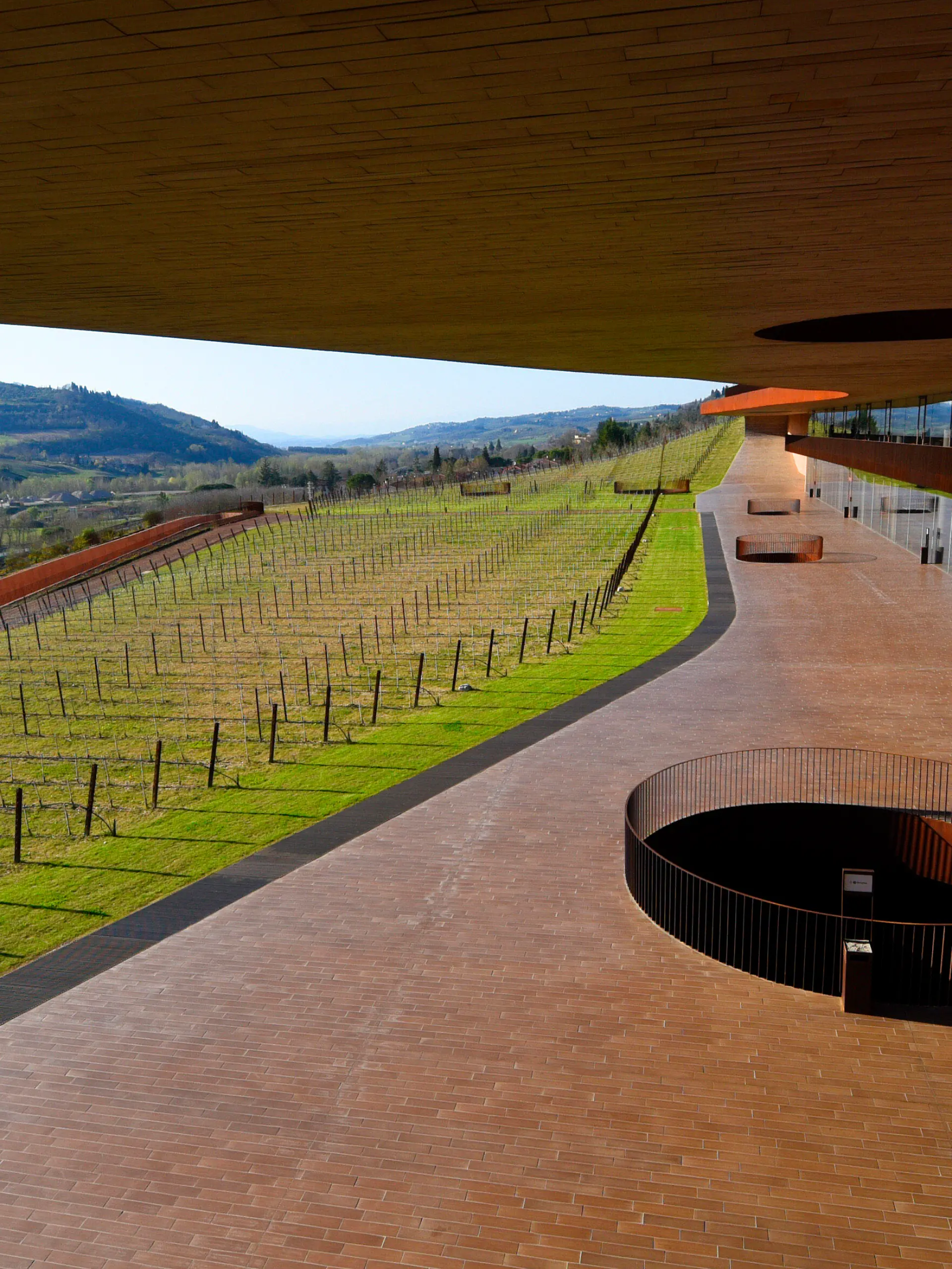 Italy , San Casciano Val di Pesa (Florence - Tuscany) - April 10, 2015 On 25 October 2012, the Cantina del Chianti Classico (winery) opened the Antinori family. A key point of the architecture should be "invisibility" the. So two slots cut into the land with vineyards in a big hill. To realize the harmony with the landscape, it was decided to pull over the whole building with a vineyard. In earth tones brown-red, the winery was built from natural materials such as terracotta, wood, corten steel and wood. The building includes besides the winery still family museum and wine sales.The wine celler was designed by Studio Hydea and the Florentine architect Marco Casamonti. The Cantina Antinori is the new headquarters of a historic family-owned company. Photo: View from the spiral staircase of the vineyards |