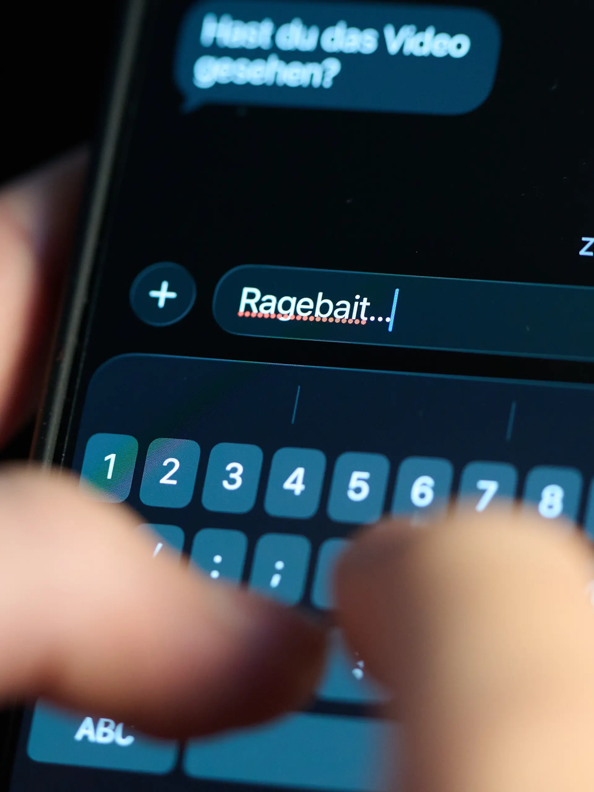 Das Wort „Ragebait” ist auf dem Display eines Smartphones in einem Chatverlauf zu lesen. (gestellte Szene)