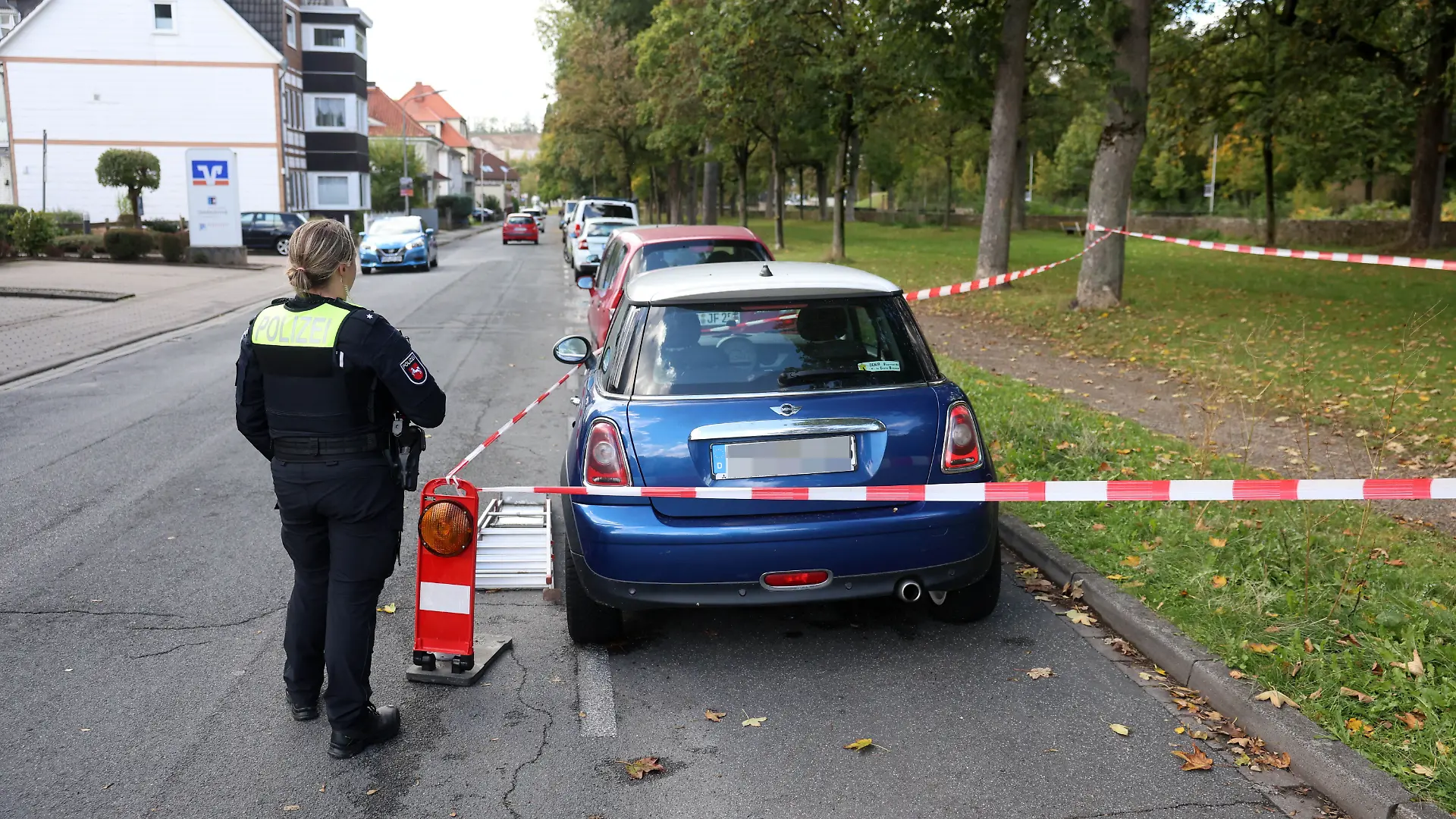 Rätsel um den blauen Mini! Eine Polizistin sichert das mit Absperrband umgebene Auto in Osterode. Ganz in der Nähe wurde ein 37-Jähriger tot gefunden.