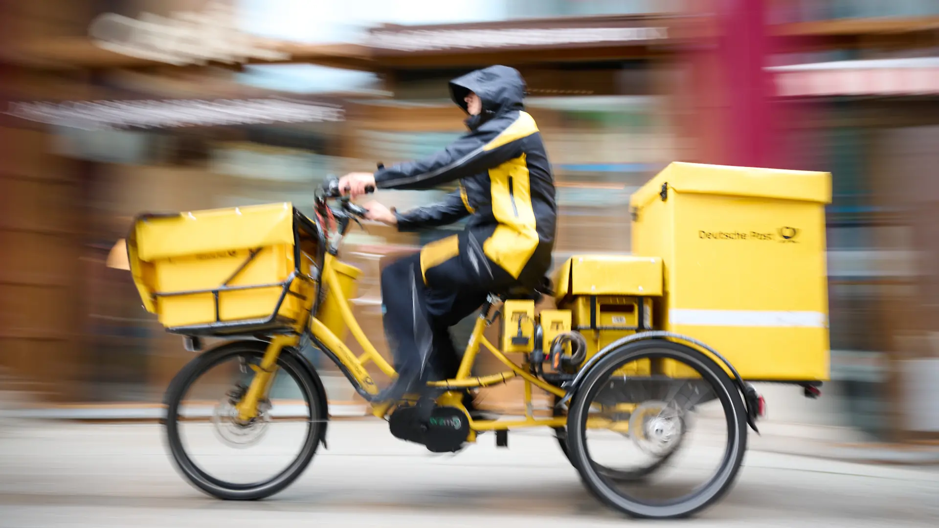 Ein Postbote stellt Briefe mit einem Postfahrrad zu. Die Deutsche Post wird das Briefporto zum Jahreswechsel aller Voraussicht nach so stark anheben wie noch nie, der bislang 95 Cent teure Standardbrief-Versand dürfte dann zwischen 1,10 und 1,15 Euro kosten. (zu dpa: «Plus 20 Prozent: Porto kann so stark steigen wie noch nie») +++ dpa-Bildfunk +++