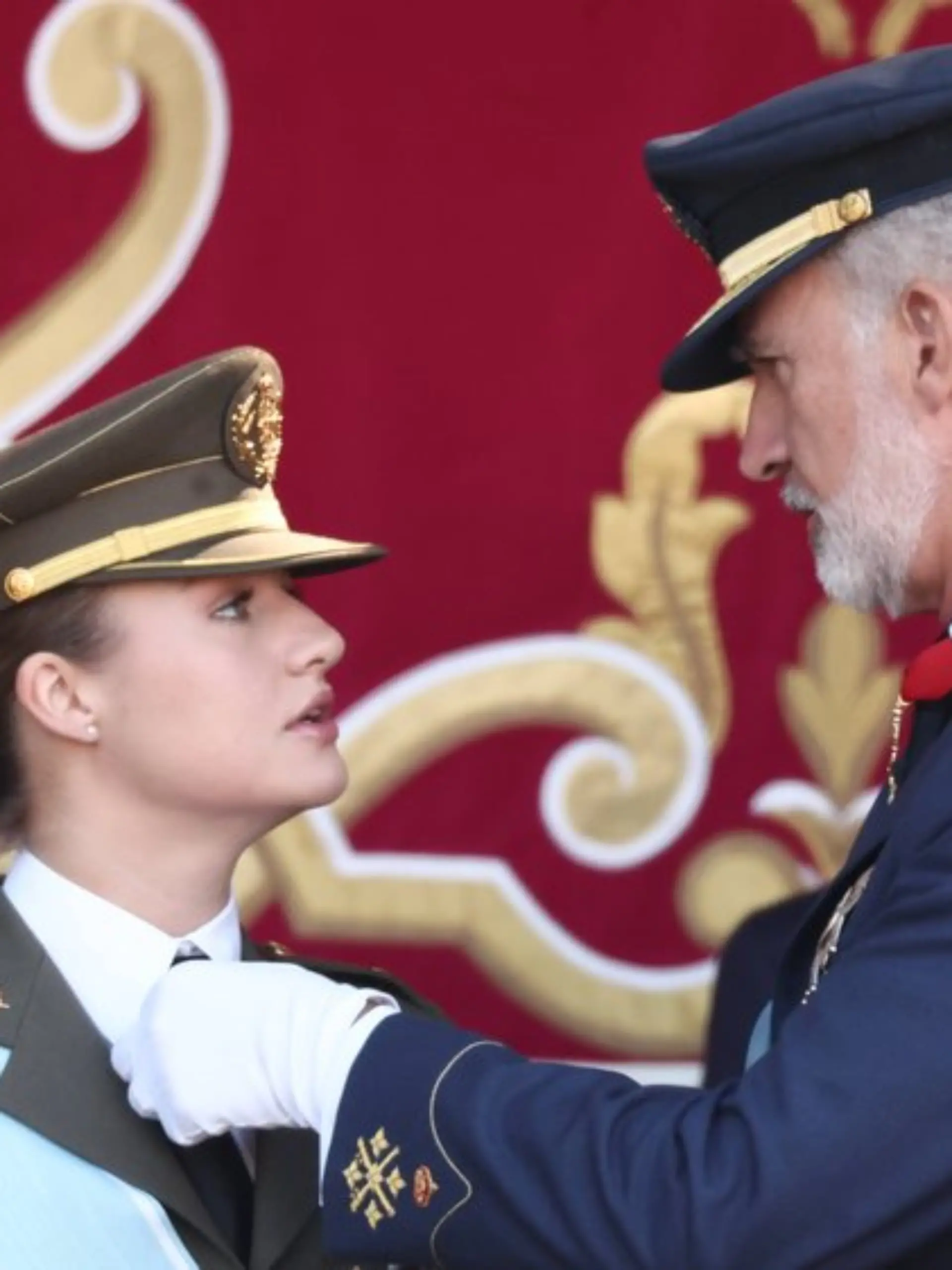 König Felipe hilft Prinzessin Leonor beim Ordnen ihrer Uniform.