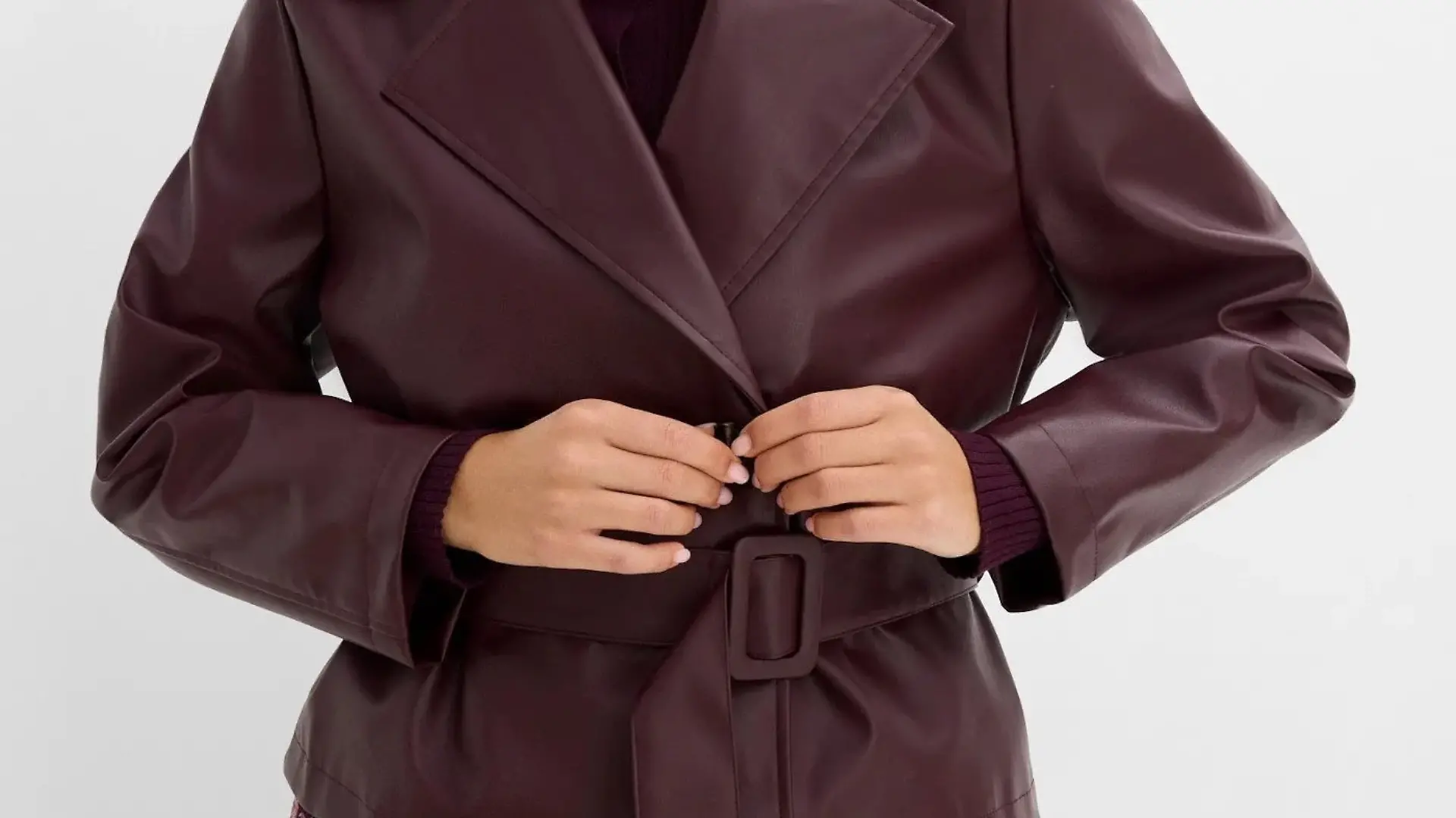 Ein Model trägt eine dunkelrote Trenchjacke von Bonprix.