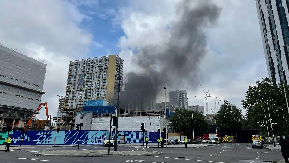 Emergency services at the scene of a fire that has broken out at garages close to Elephant and Castle railway station in London, Monday, June 28, 2021. Responding to videos posted on Twitter, the London Fire Brigade said Monday that 10 fire engines and 70 firefighters were battling the blaze at railway arches near the station, which is just south of the River Thames and near some major London landmarks, including the London Eye. (PA 
via AP)