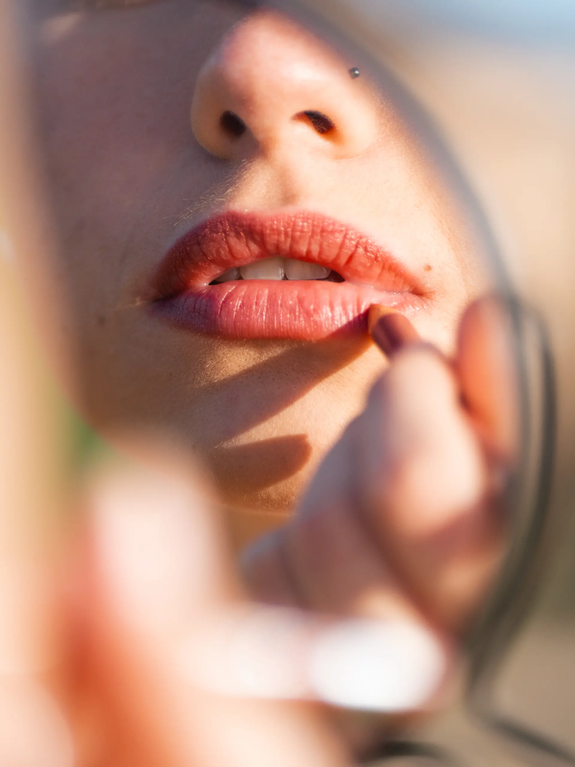 Nahaufnahme: Frau malt ihre Lippen mit Lippenstift an.