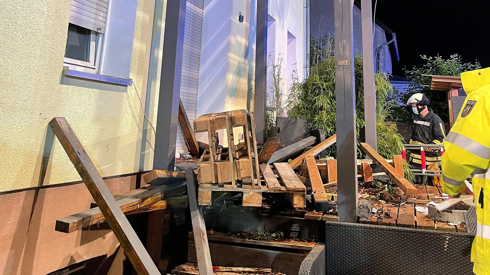 HANDOUT - 27.06.2021, Nordrhein-Westfalen, Bad Meinberg: Rettungskräfte stehen neben den Trümmern eines Balkons aus Holz, der mit mehreren Menschen darauf eingestürzt ist. Beim Einsturz eines Balkons im Kreis Lippe sind neun Menschen verletzt worden, fünf von ihnen schwer. Ein Schwerverletzter schwebe in Lebensgefahr, sagte ein Polizeisprecher. Foto: Freiwillige Feuerwehr/Horn-Bad Meinberg/dpa +++ dpa-Bildfunk +++