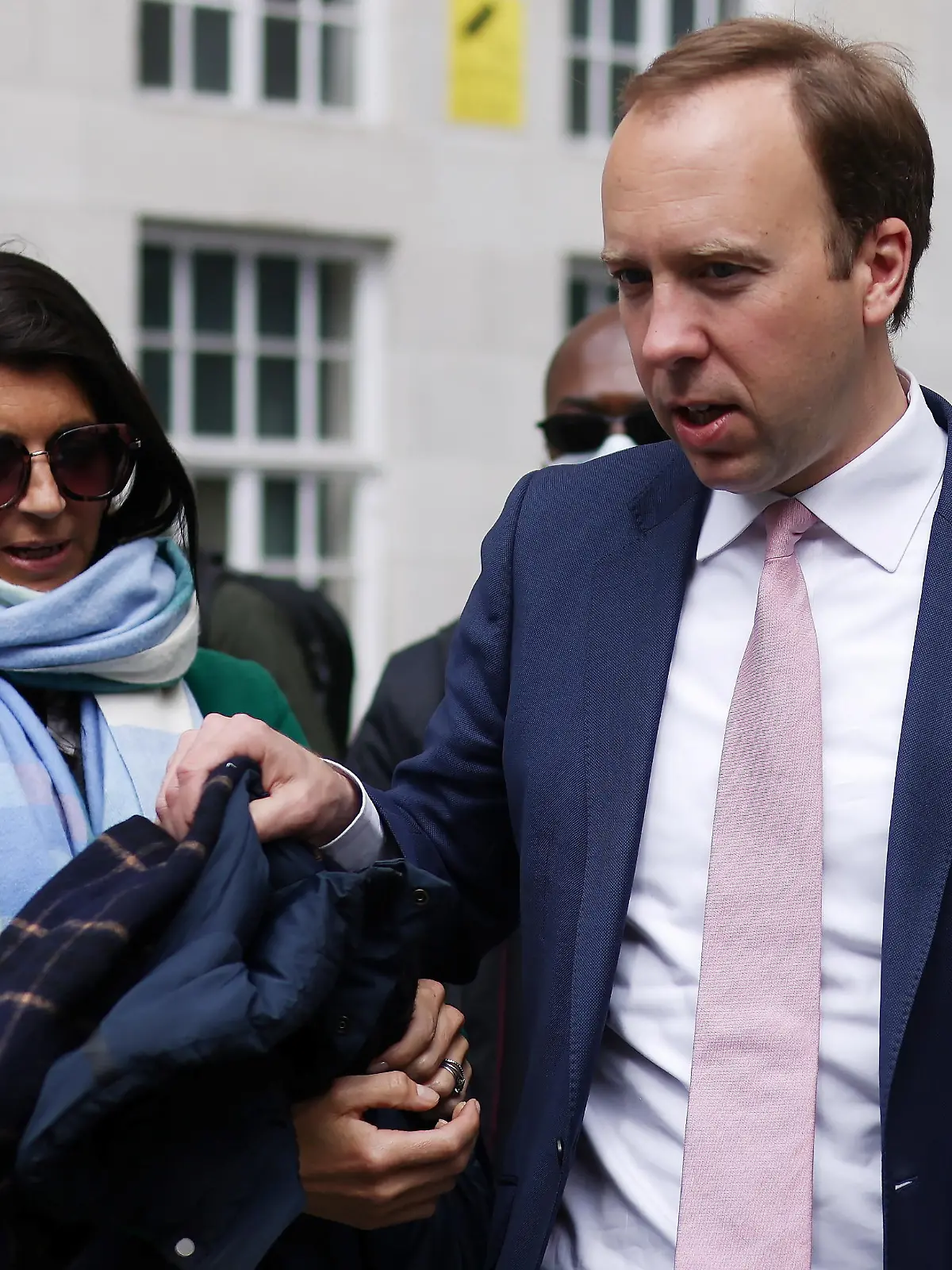 Britain's Health Secretary Matt Hancock hands his coat to his aide Gina Coladangelo (L) before a television interview outside BBC's Broadcasting House in London, Britain, May 16, 2021. Picture taken May 16, 2021. REUTERS/Tom Nicholson